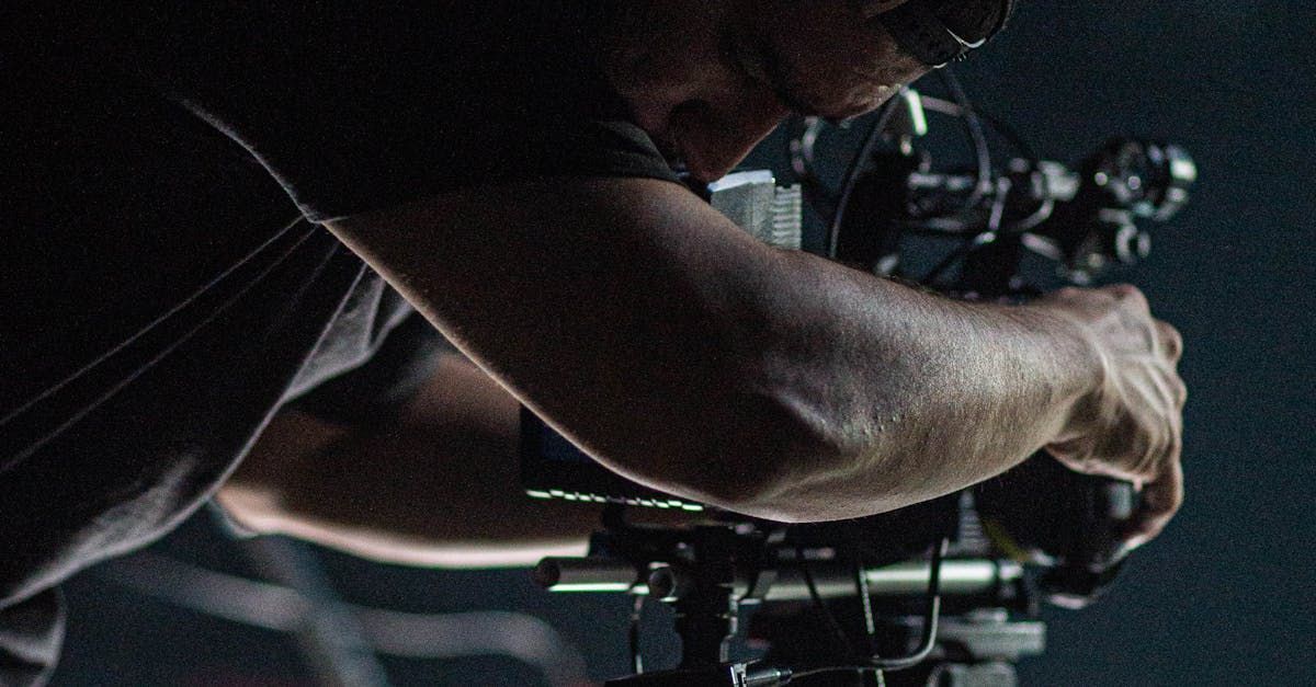 A man is holding a camera in his hands in a dark room.