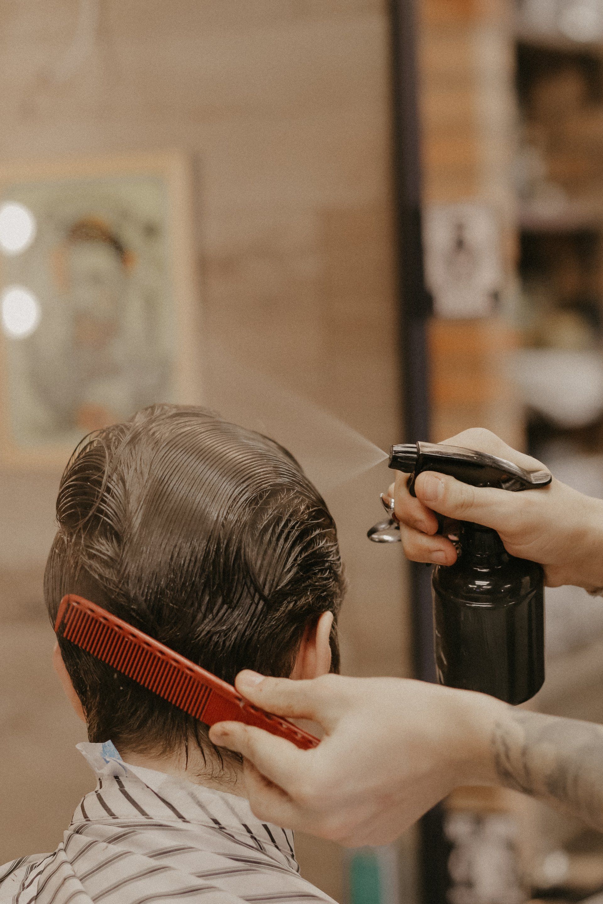 A man is getting his hair cut by a barber in a barber shop.