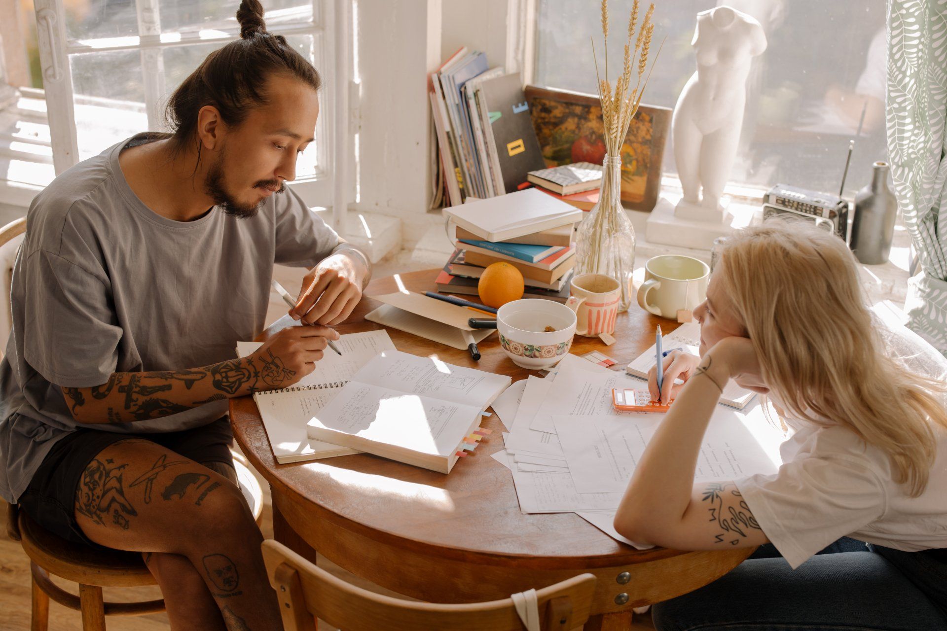 a man and a woman are sitting at a table with papers on it .