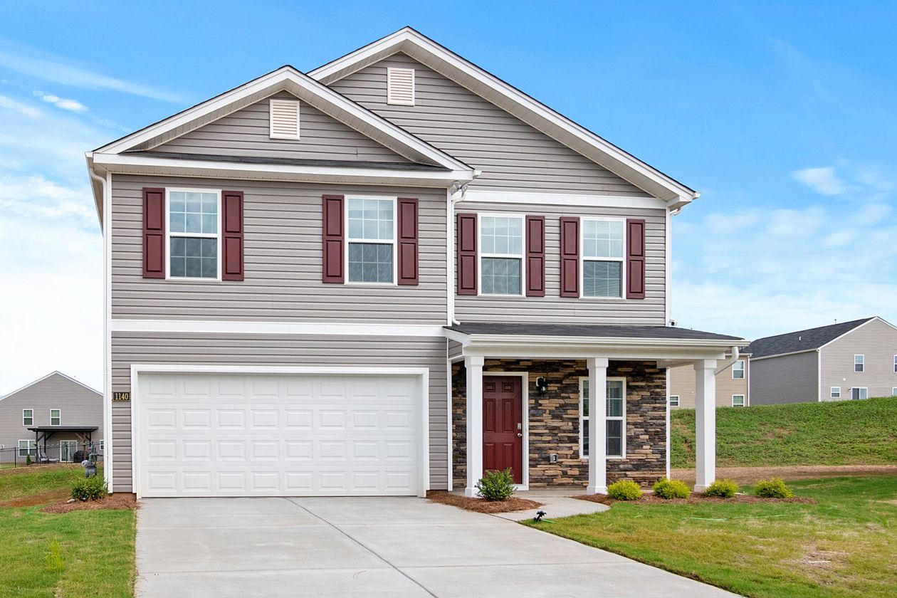 A large house with a white garage door and red door