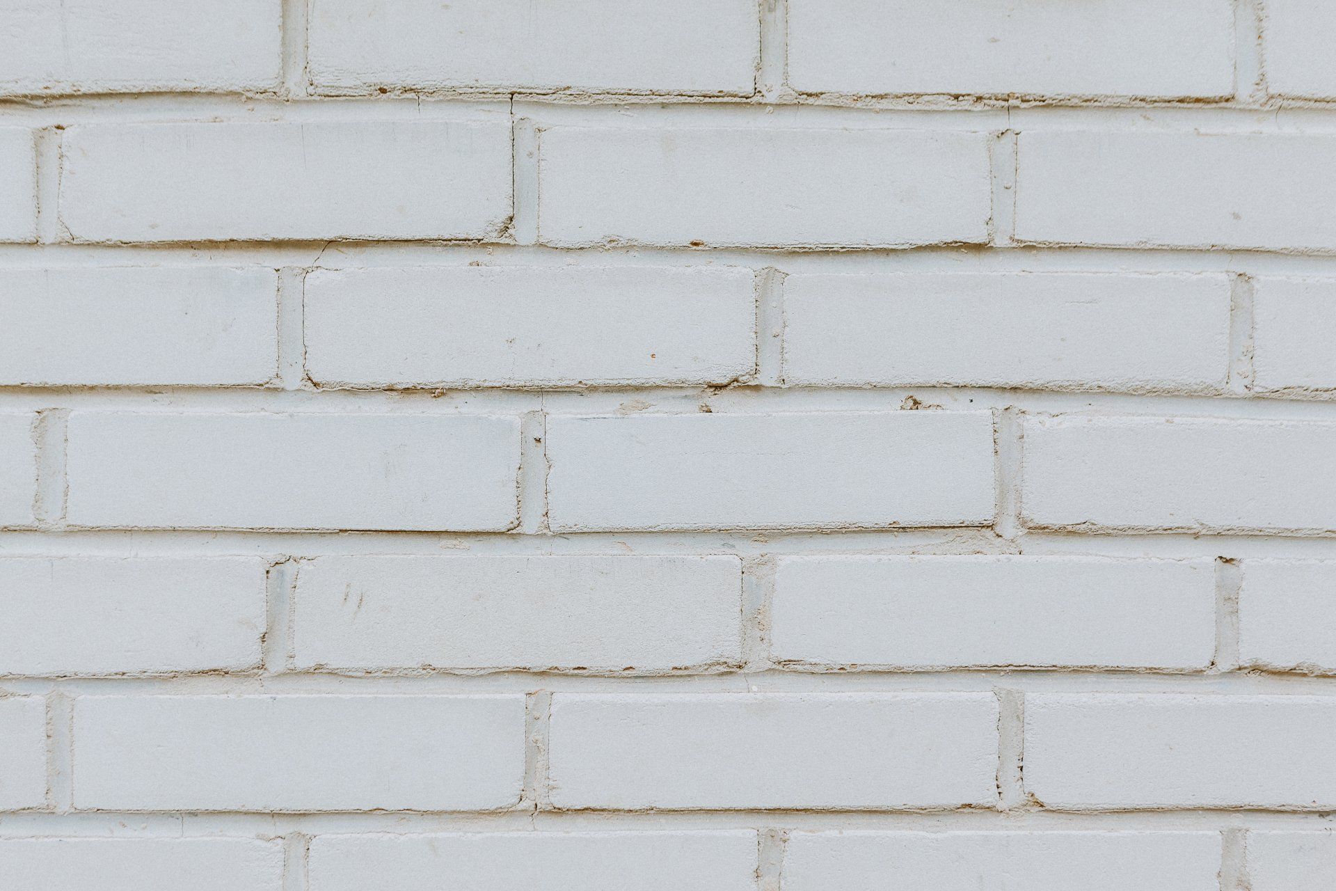 White painted brick wall with horizontal mortar lines and a slightly worn texture