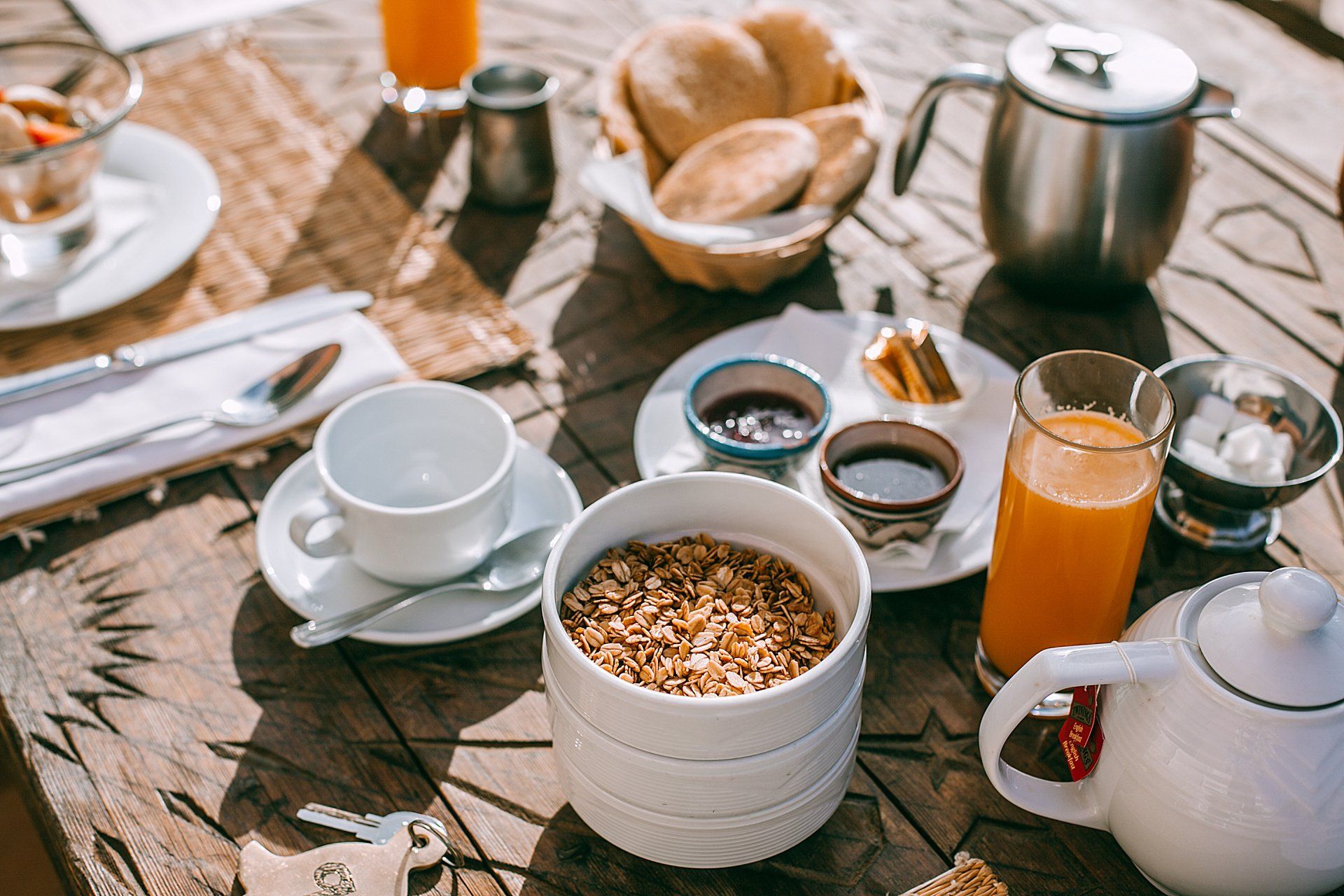 Breakfast table with granola, juice, bread, and tea.