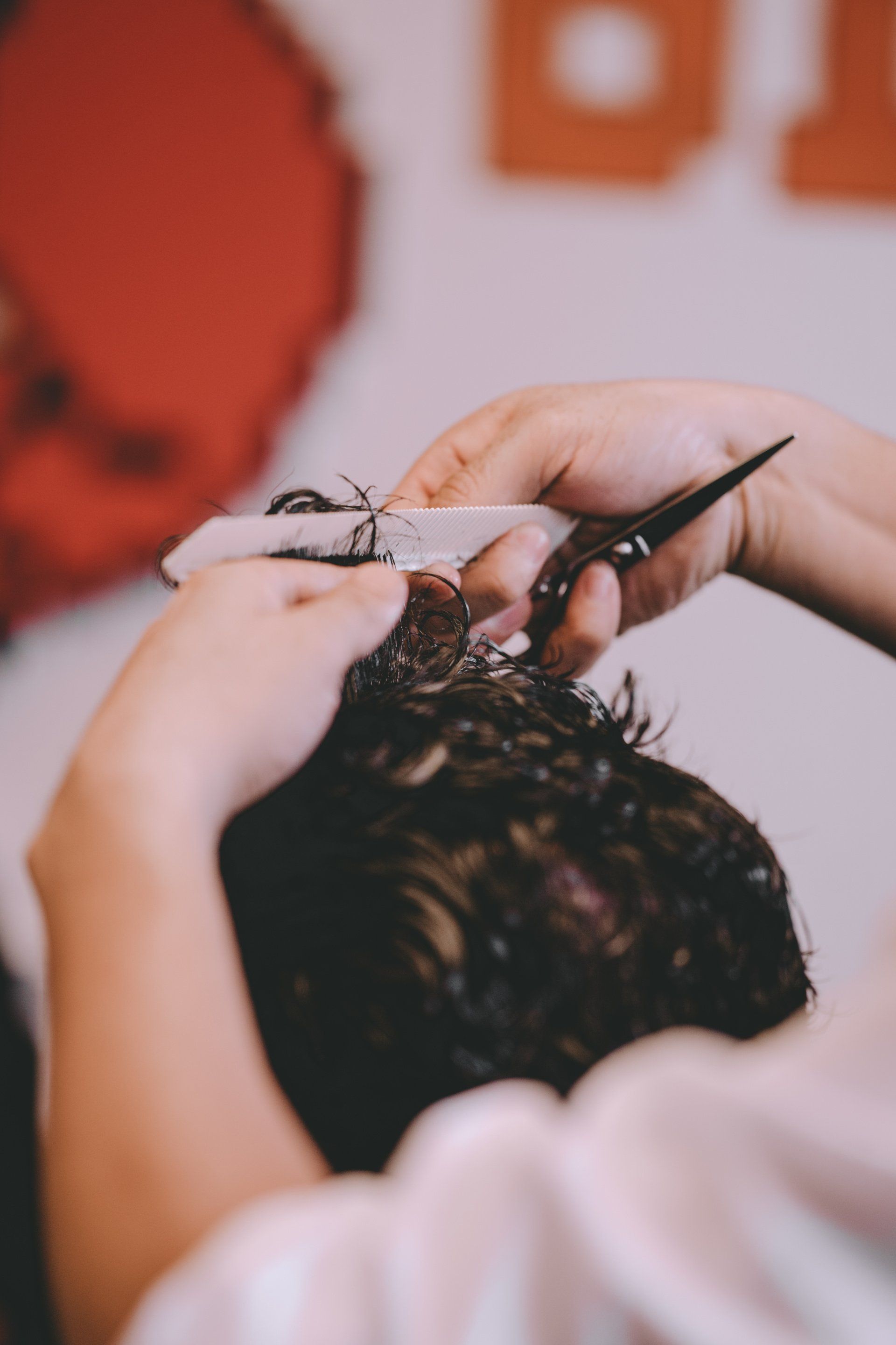 A close up of a person cutting their hair with scissors