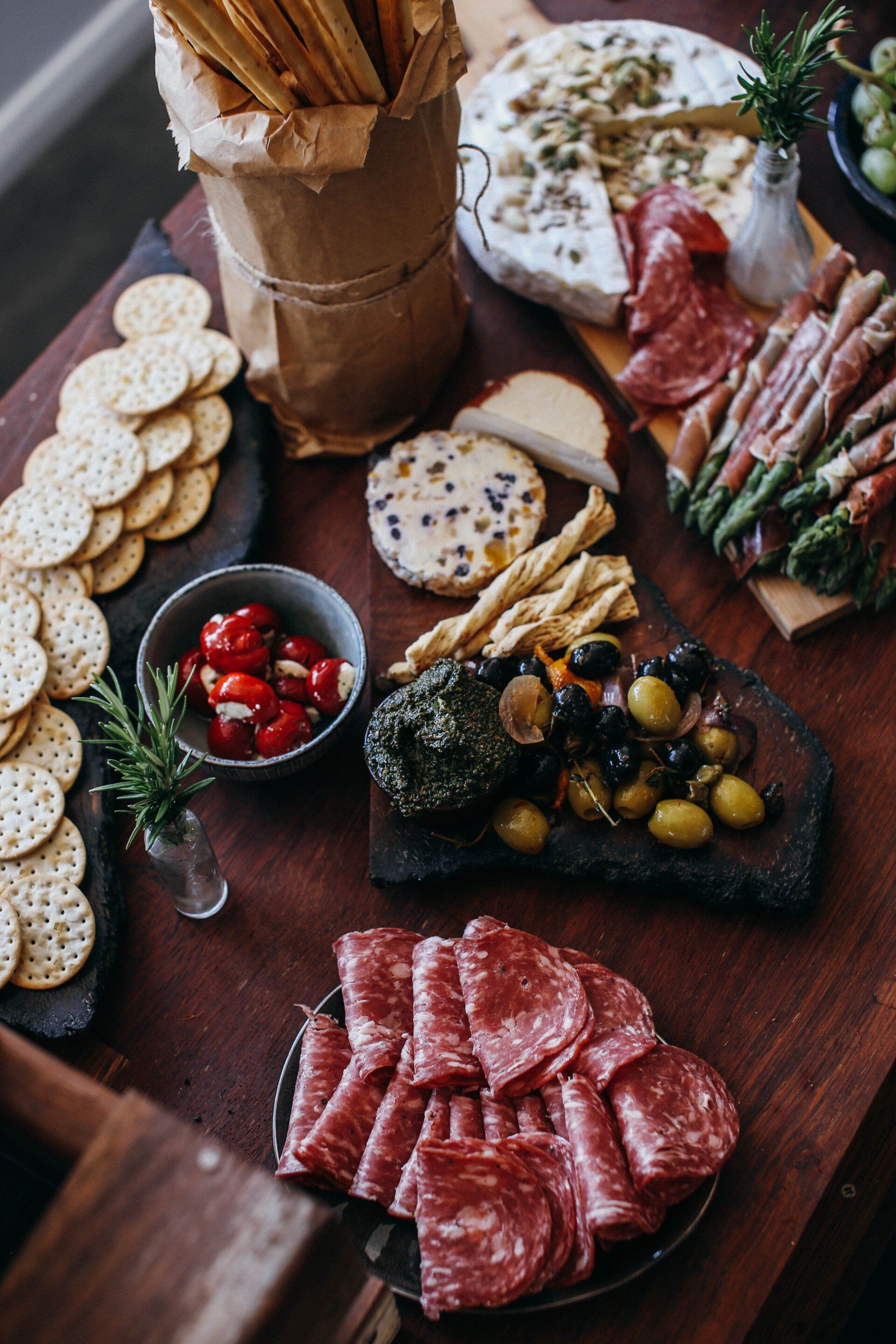 A wooden table topped with plates of food and crackers.