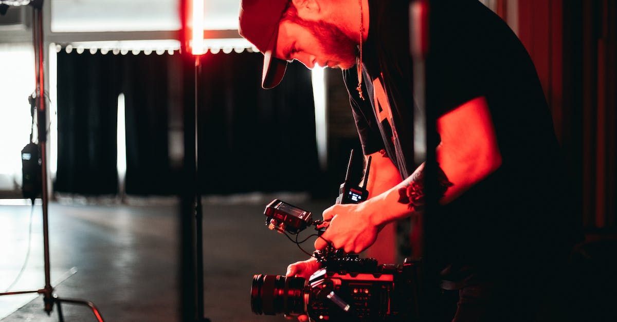 A man is holding a camera in a dark room.