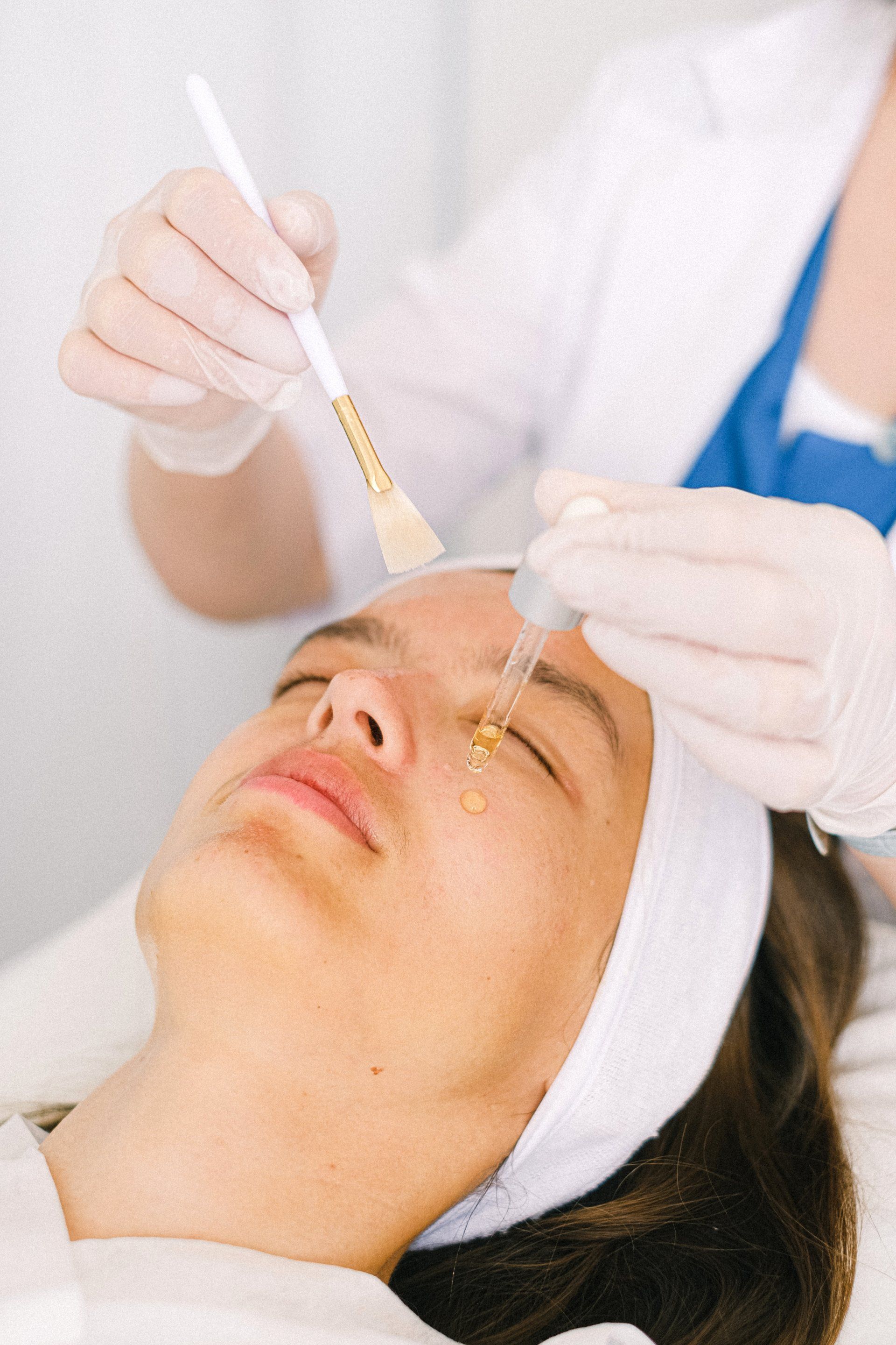 A woman is getting a fruit acid treatment at a beauty salon.