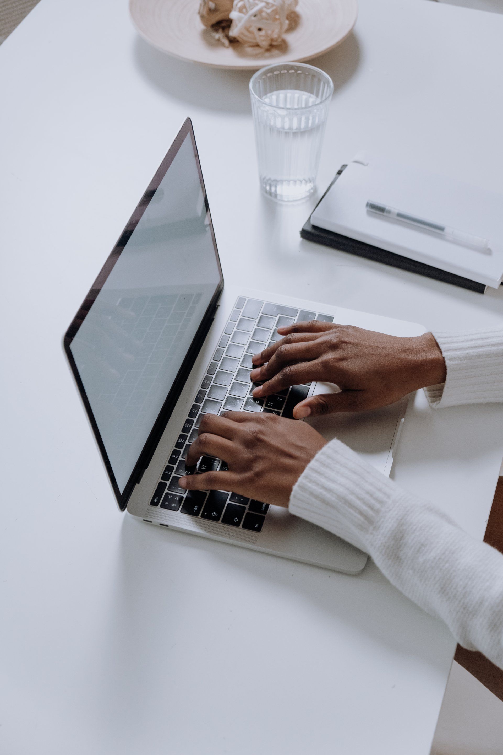 A person is typing on a laptop computer at a table.