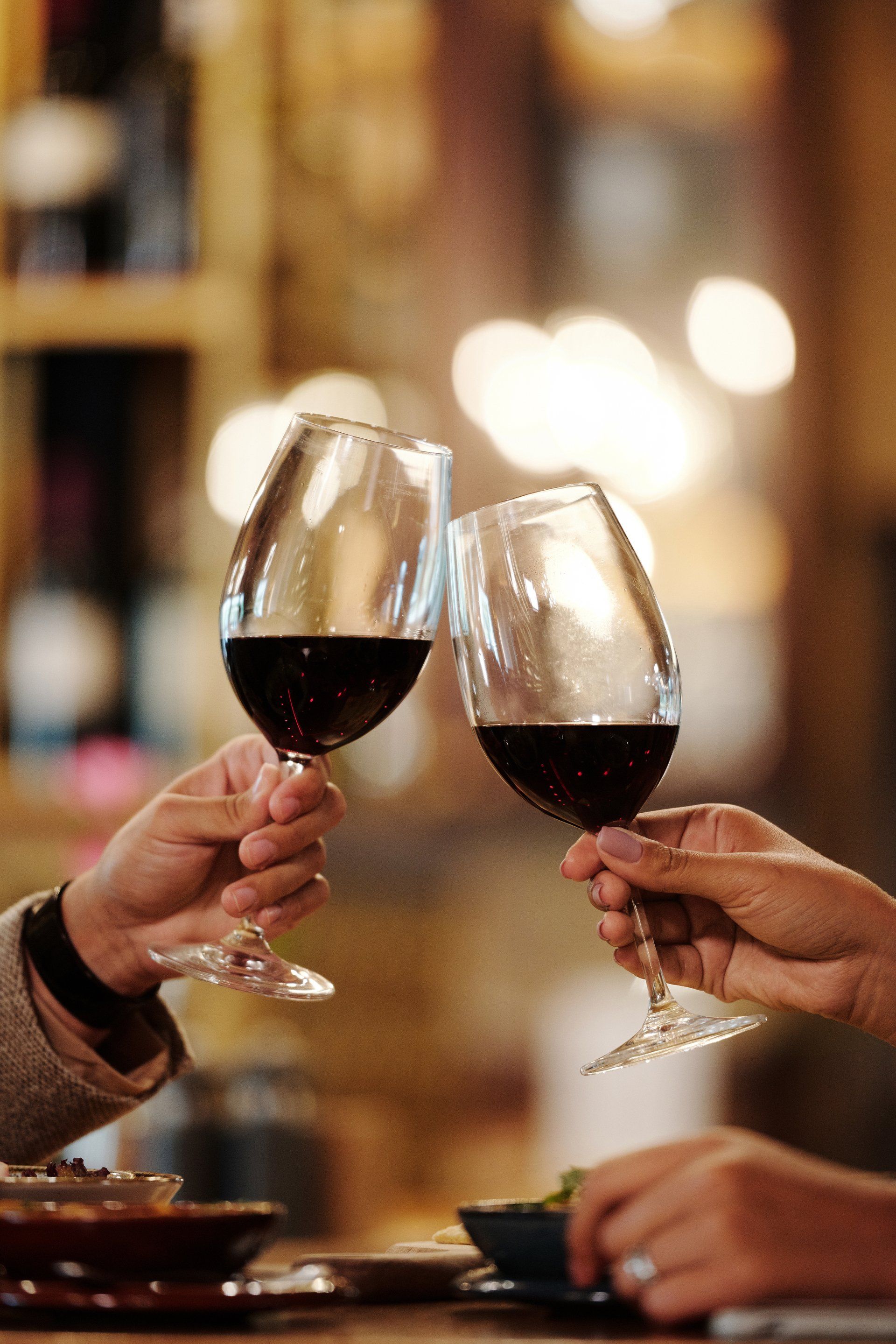 Two people are toasting with wine glasses in a restaurant.