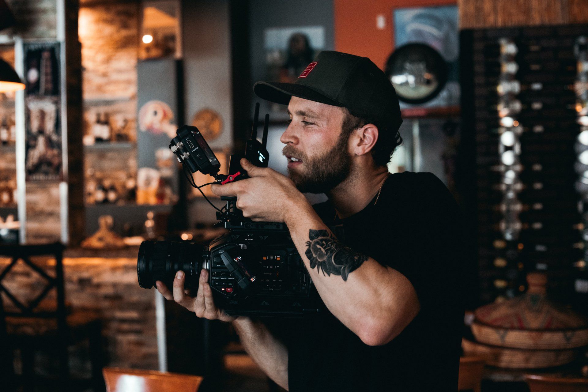 A man is holding a camera in his hands in a restaurant.