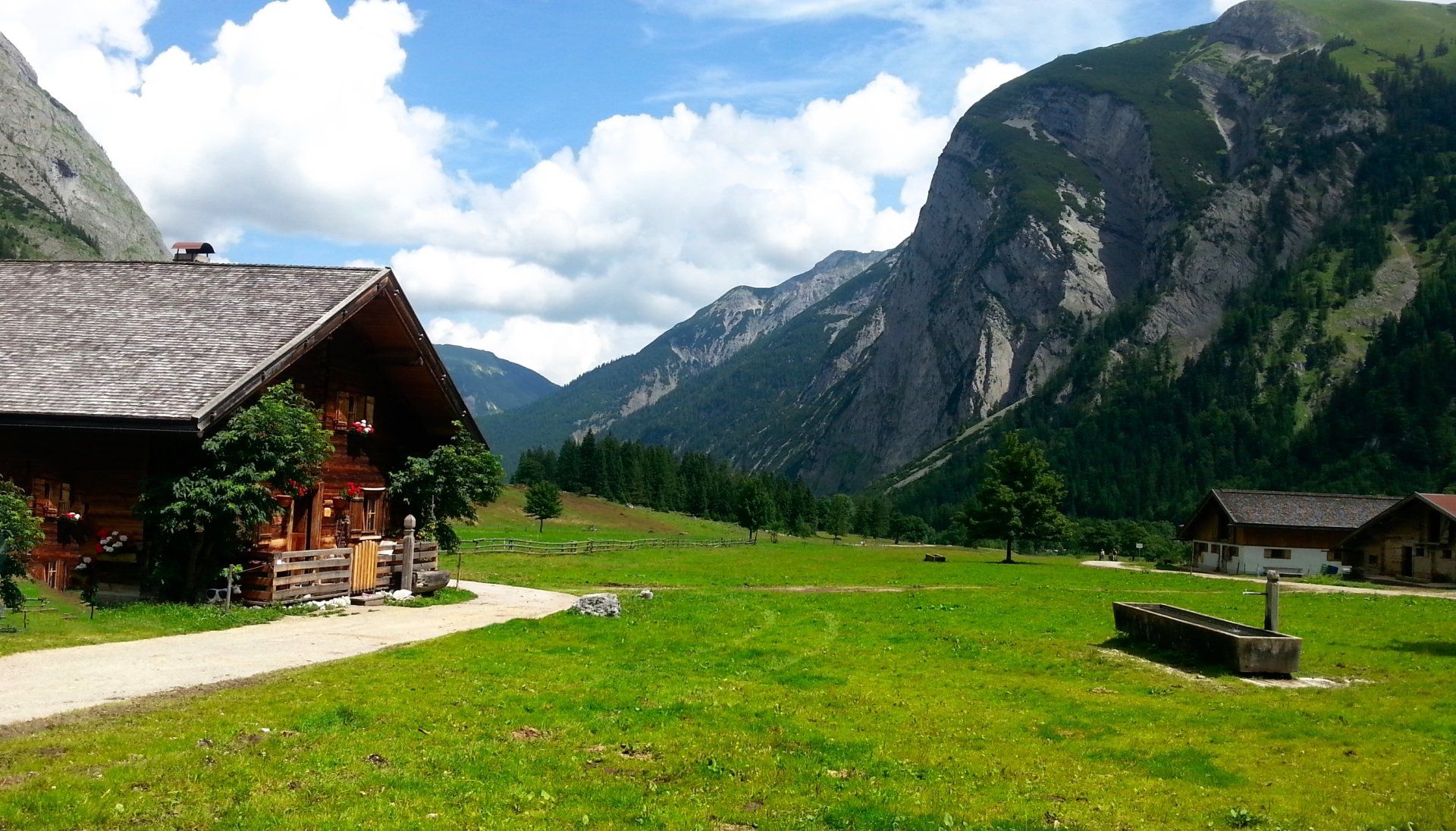 Ein Haus inmitten einer Wiese mit Bergen im Hintergrund