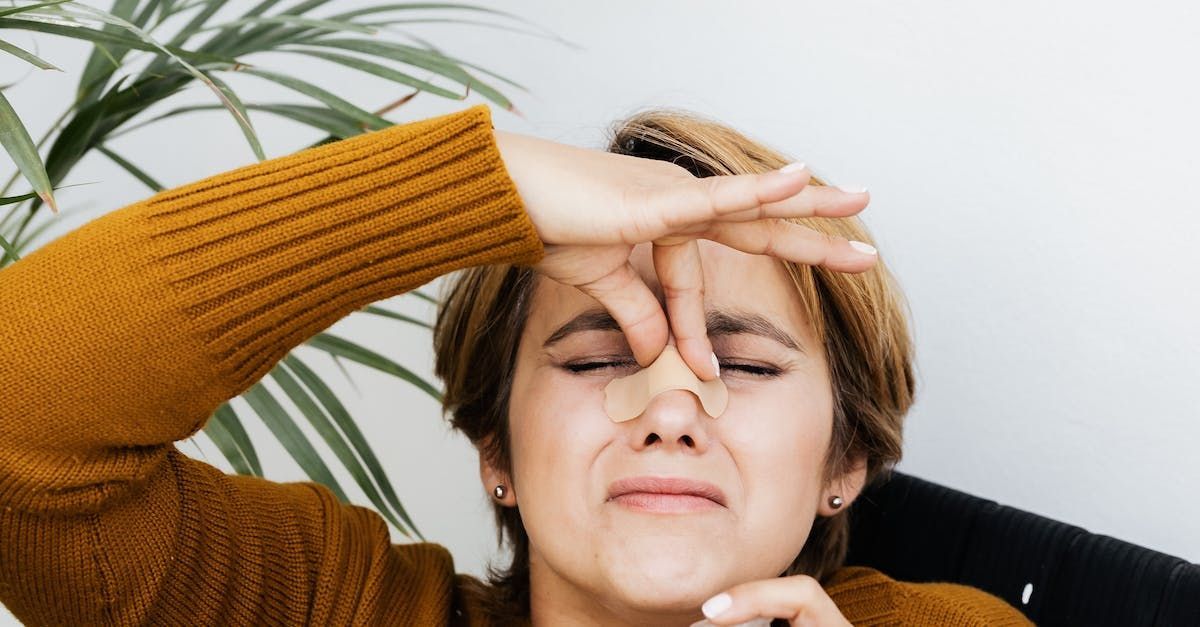a woman is holding her nose because of a bad smell .