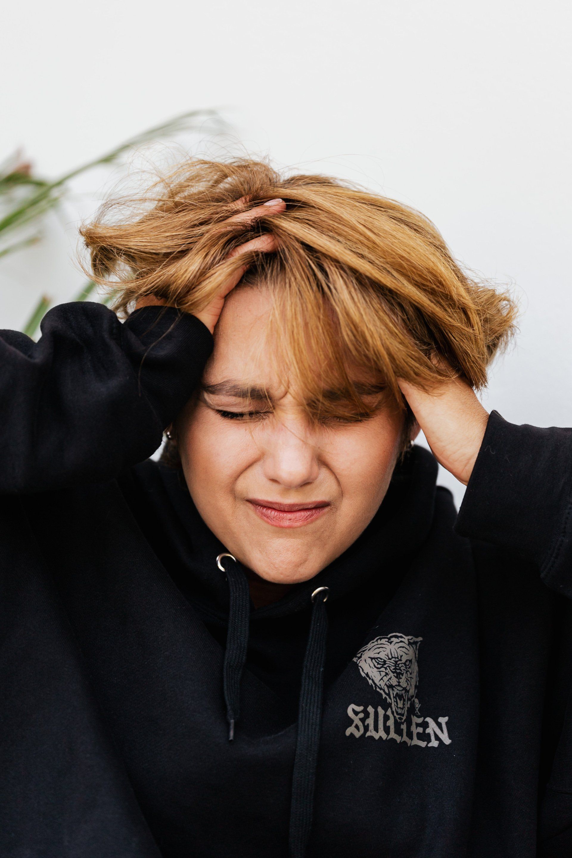 woman holding her head looking upset