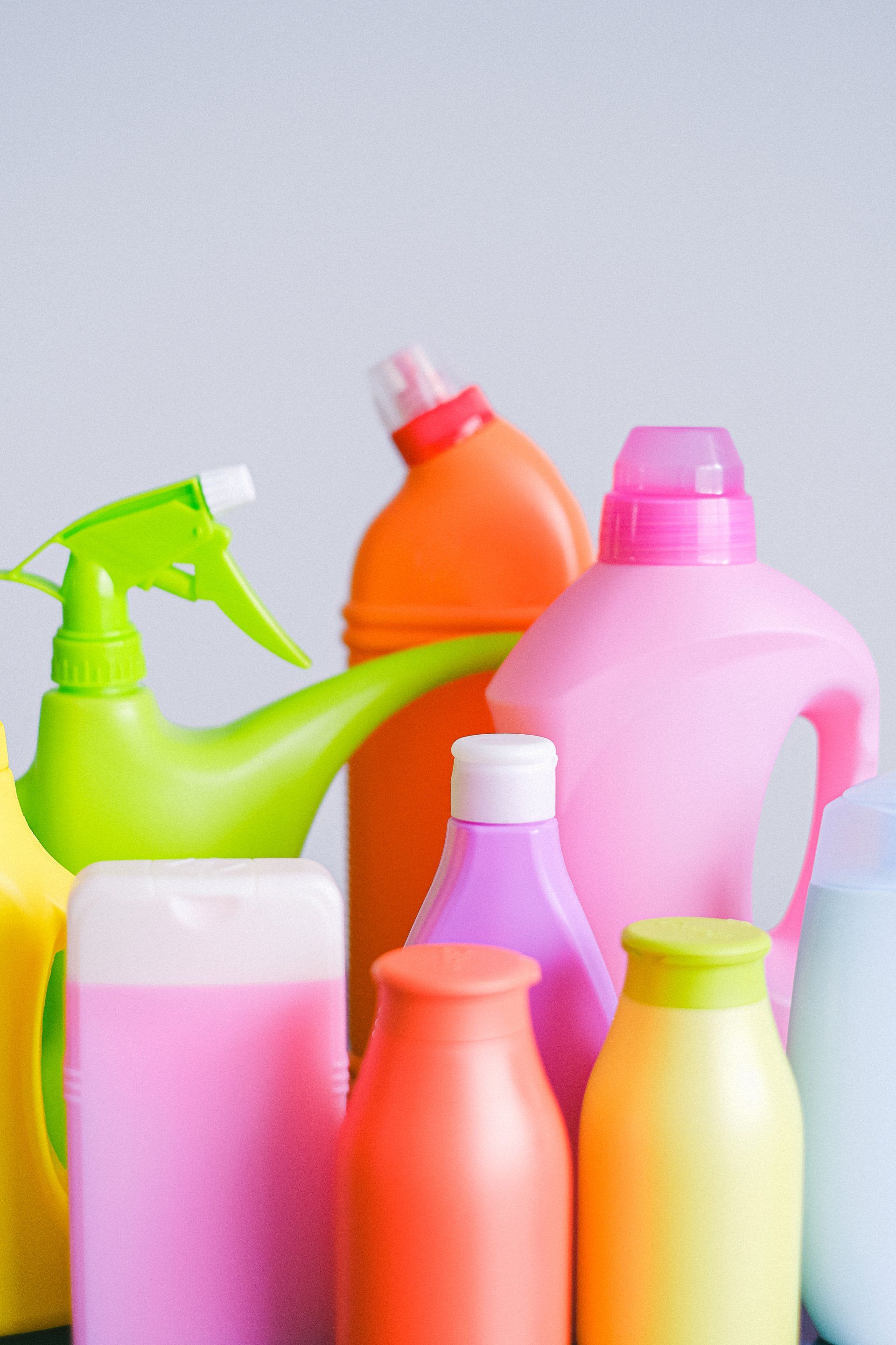 A group of colorful plastic bottles are lined up on a table.