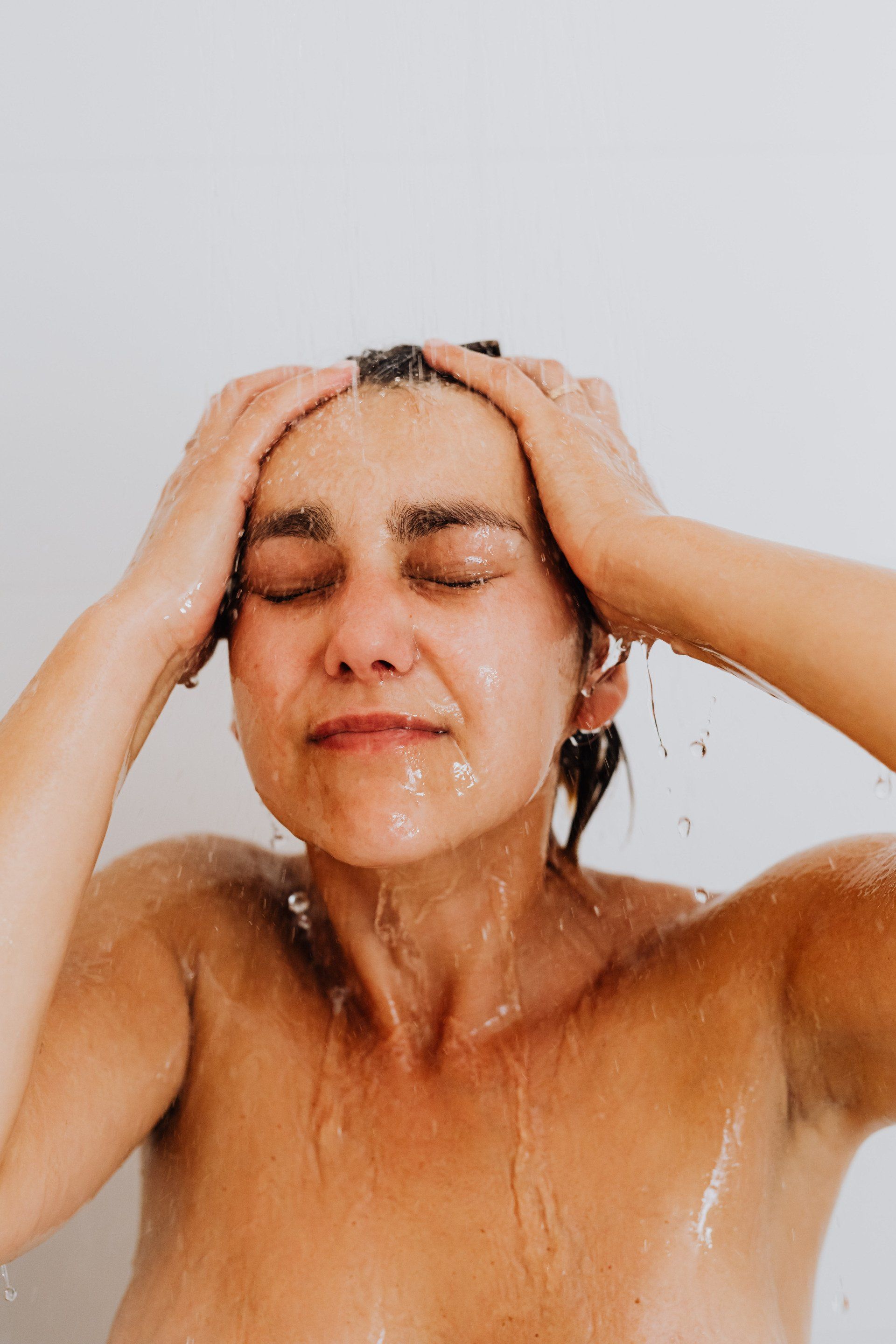 Fresh Shower Behind Wet Glass Window With Water Drops Splashing — Xtreme Seals Leaking Shower Specialists in West Wollongong, NSW