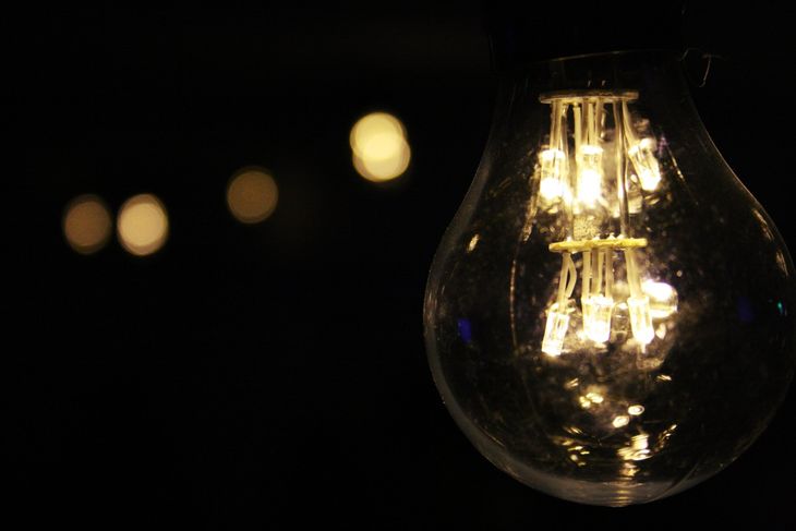 A close up of a light bulb glowing in the dark.