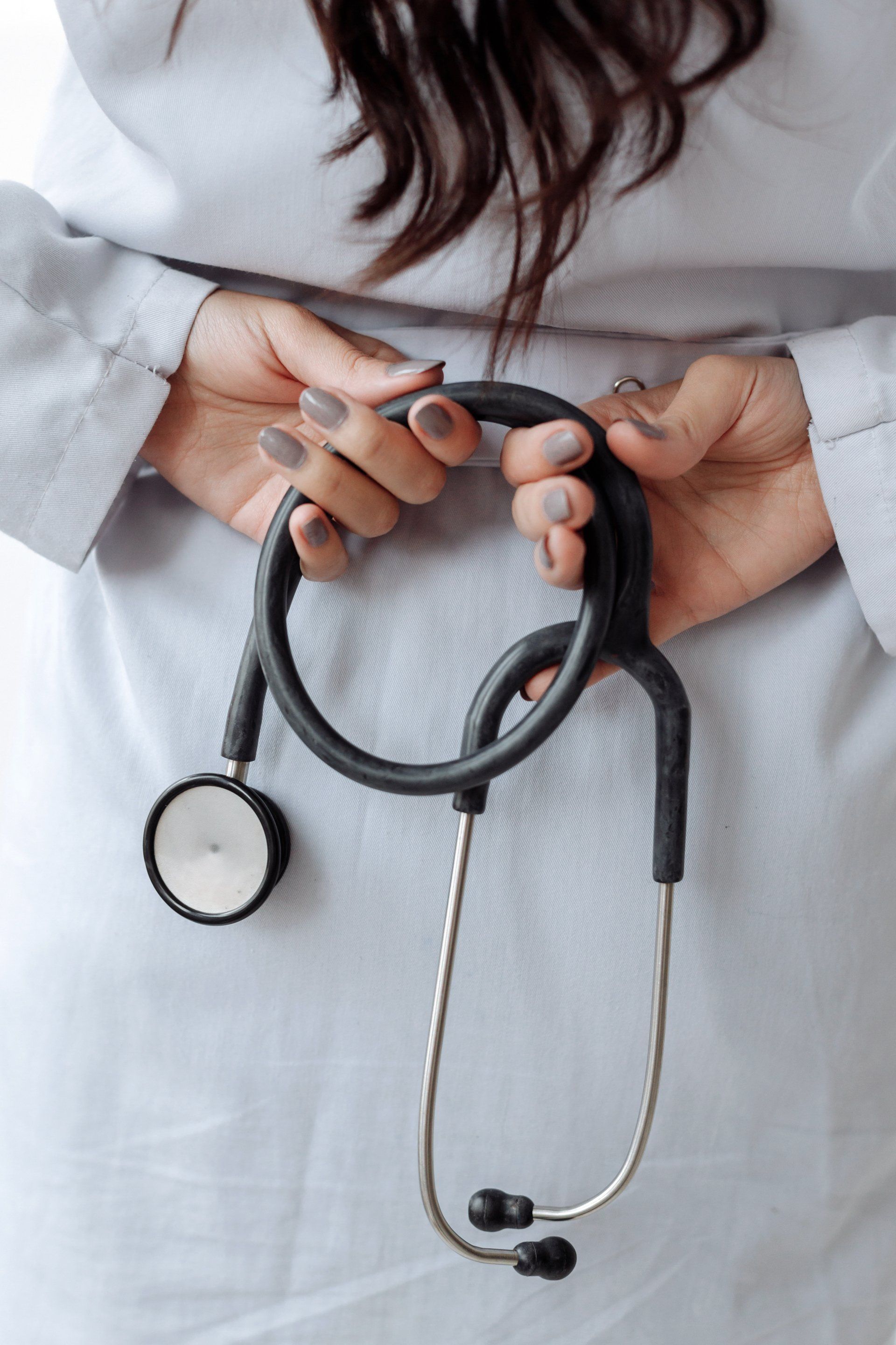 A female doctor is holding a stethoscope in her hands.