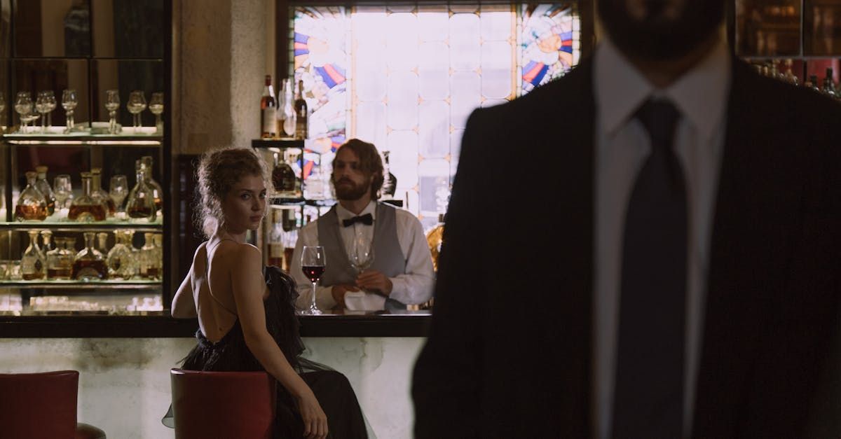 En kvinne i baren ser på en mann i dress – klassisk setting der du kan teste om hun er interessert
