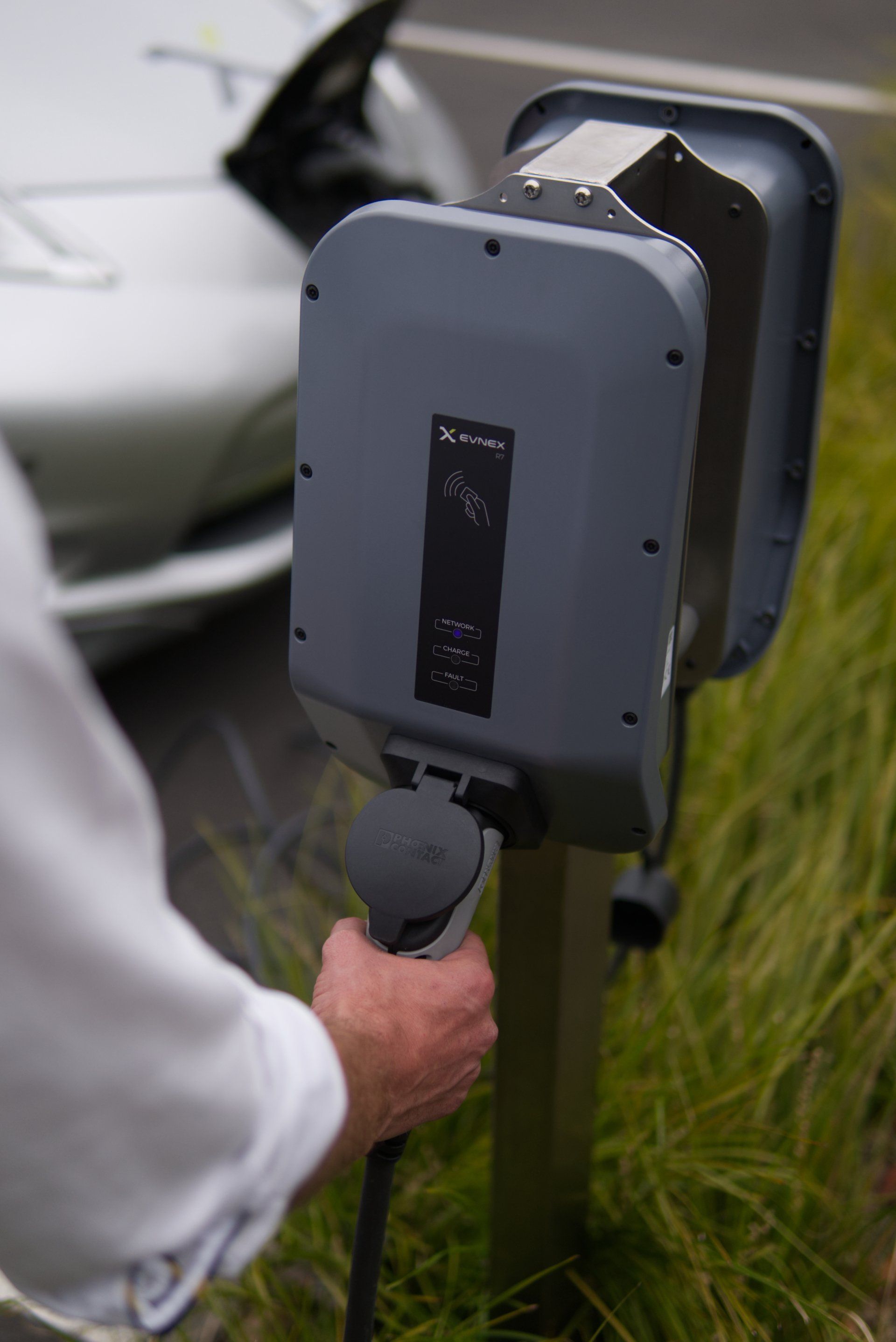 A person is charging an electric car at a charging station