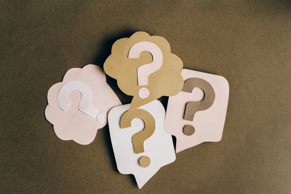 A group of paper speech bubbles with question marks on them.