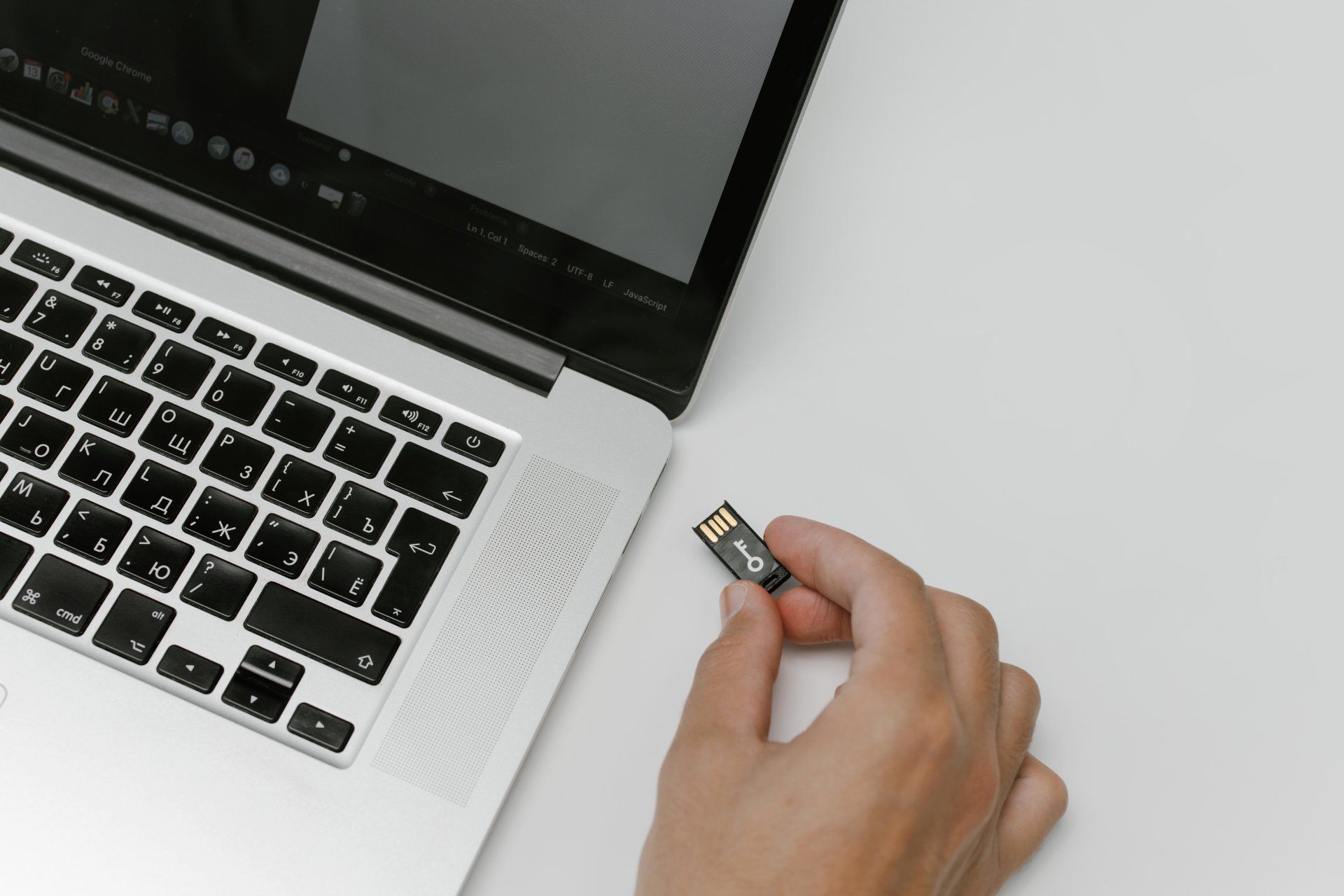 Une personne branche une clé USB sur un ordinateur portable.