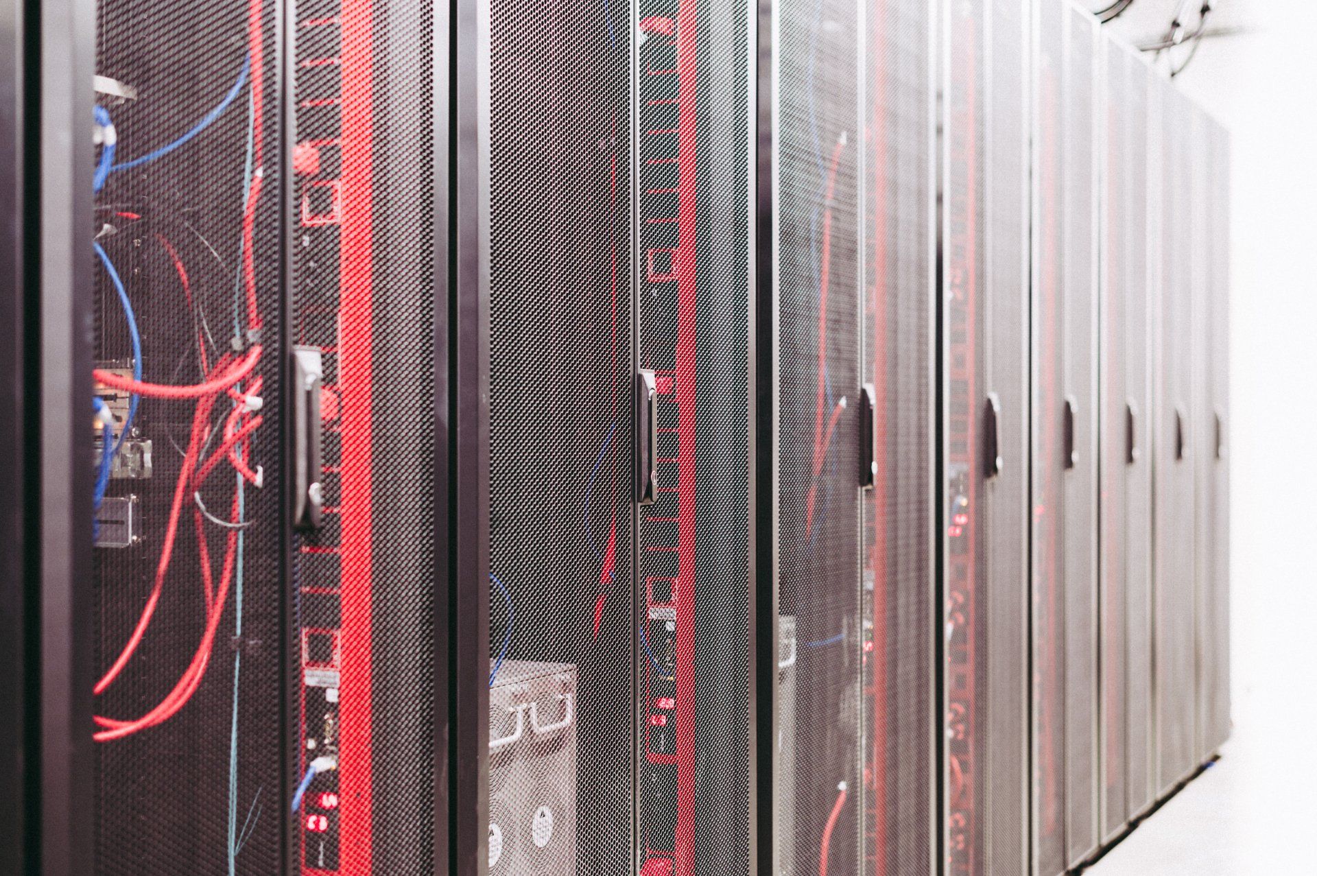Rows of servers in a data center; metal racks with red and black accents.