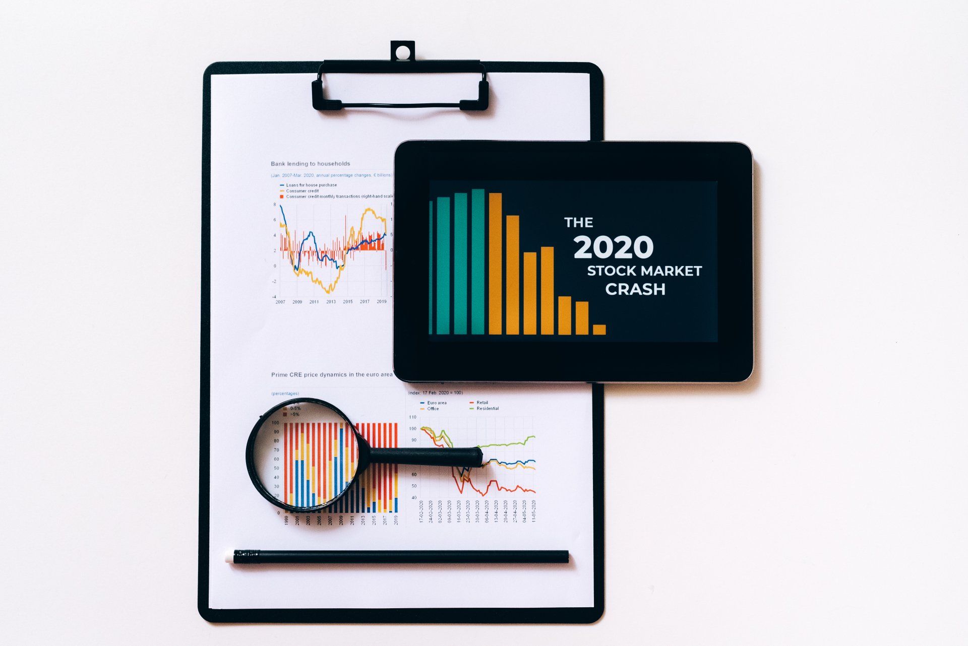 A clipboard with a magnifying glass and a tablet on it.