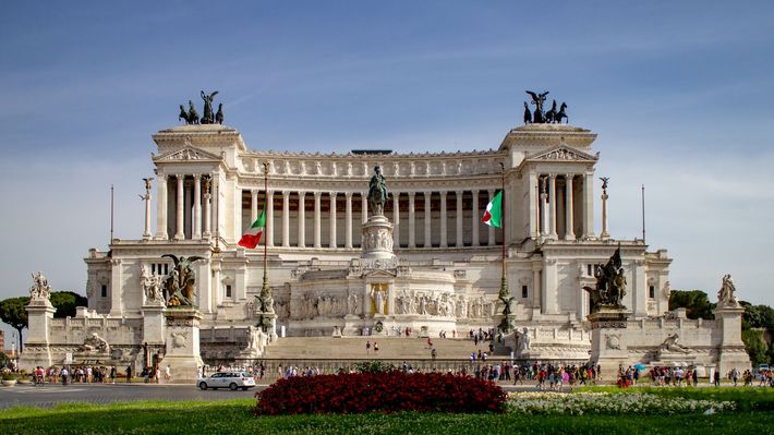 A large white building with a statue on top of it.