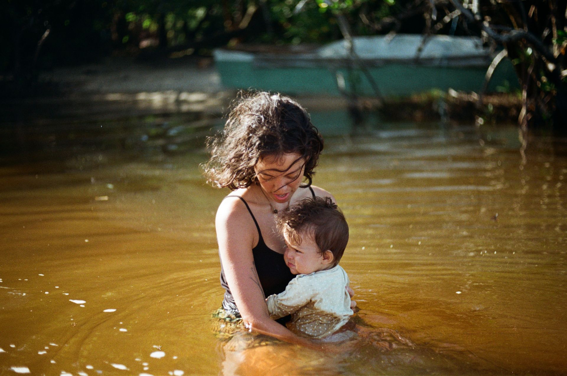 Uma mulher está segurando um bebê na água.