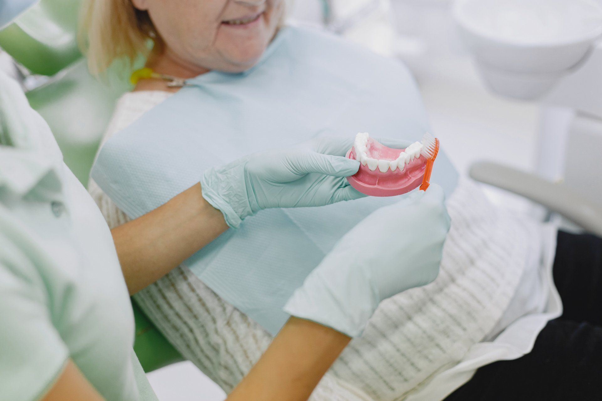 Dentist showing dentures to a patient in a dental clinic.