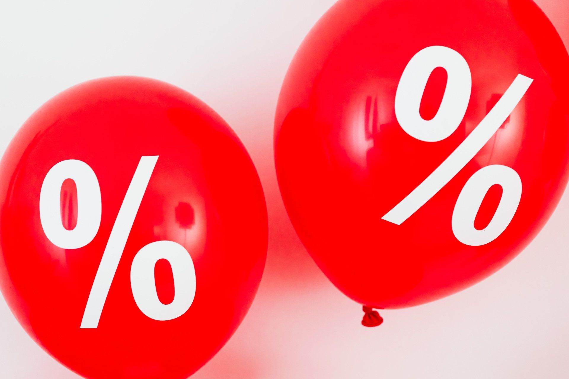 Two red balloons with percent symbols on them