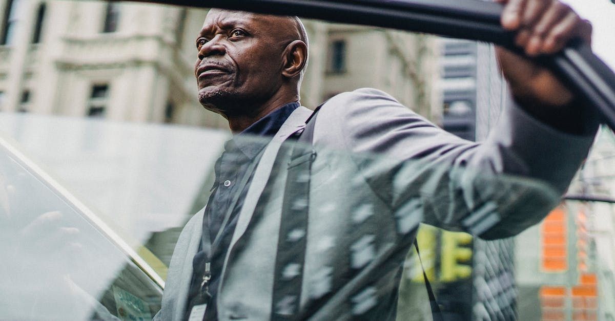 A man in a suit is looking out of the window of a Reading Taxi
