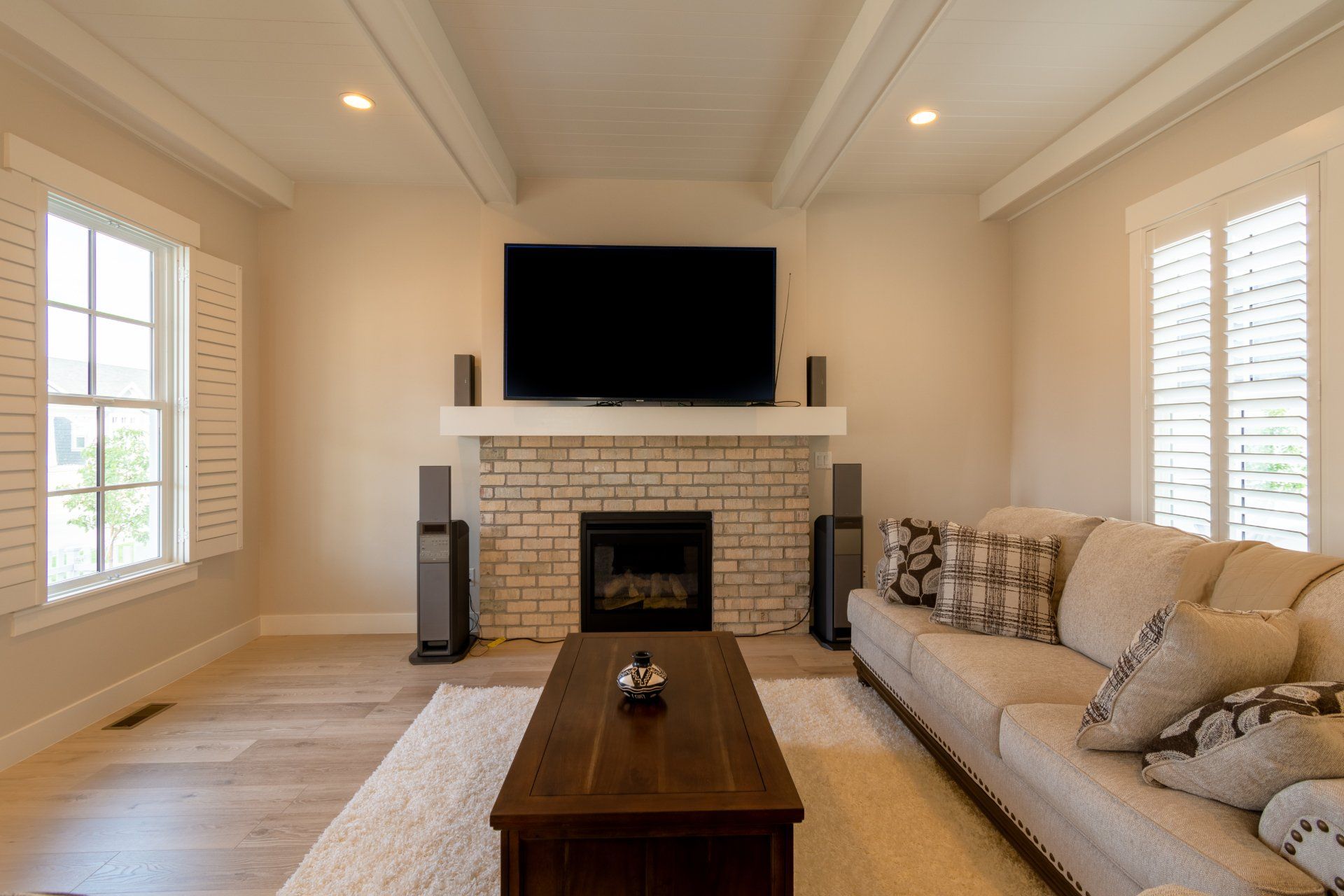A living room with a fireplace , couch , coffee table and television.