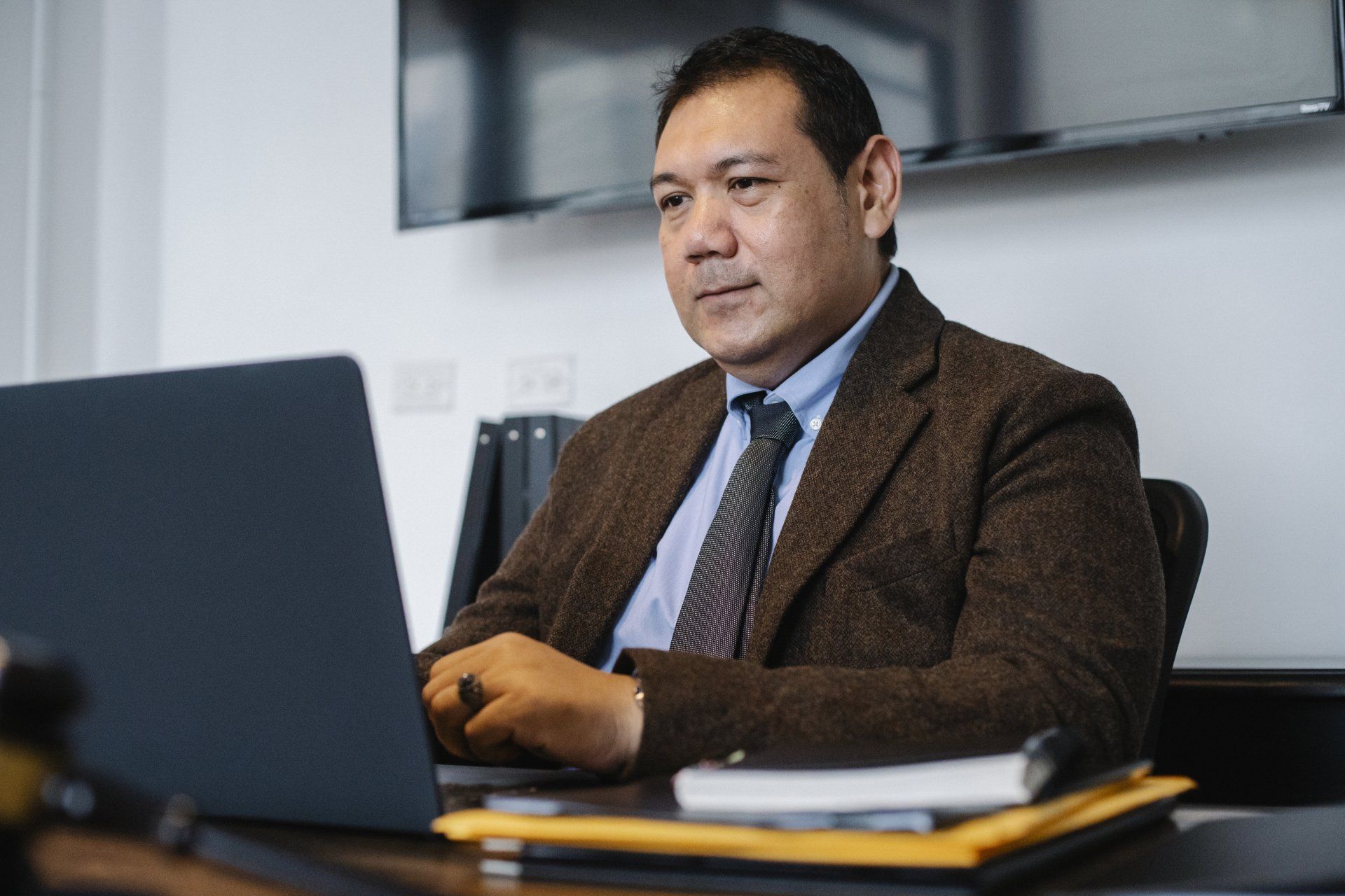 man behind desk at computer looking for a dental office builder on the computer