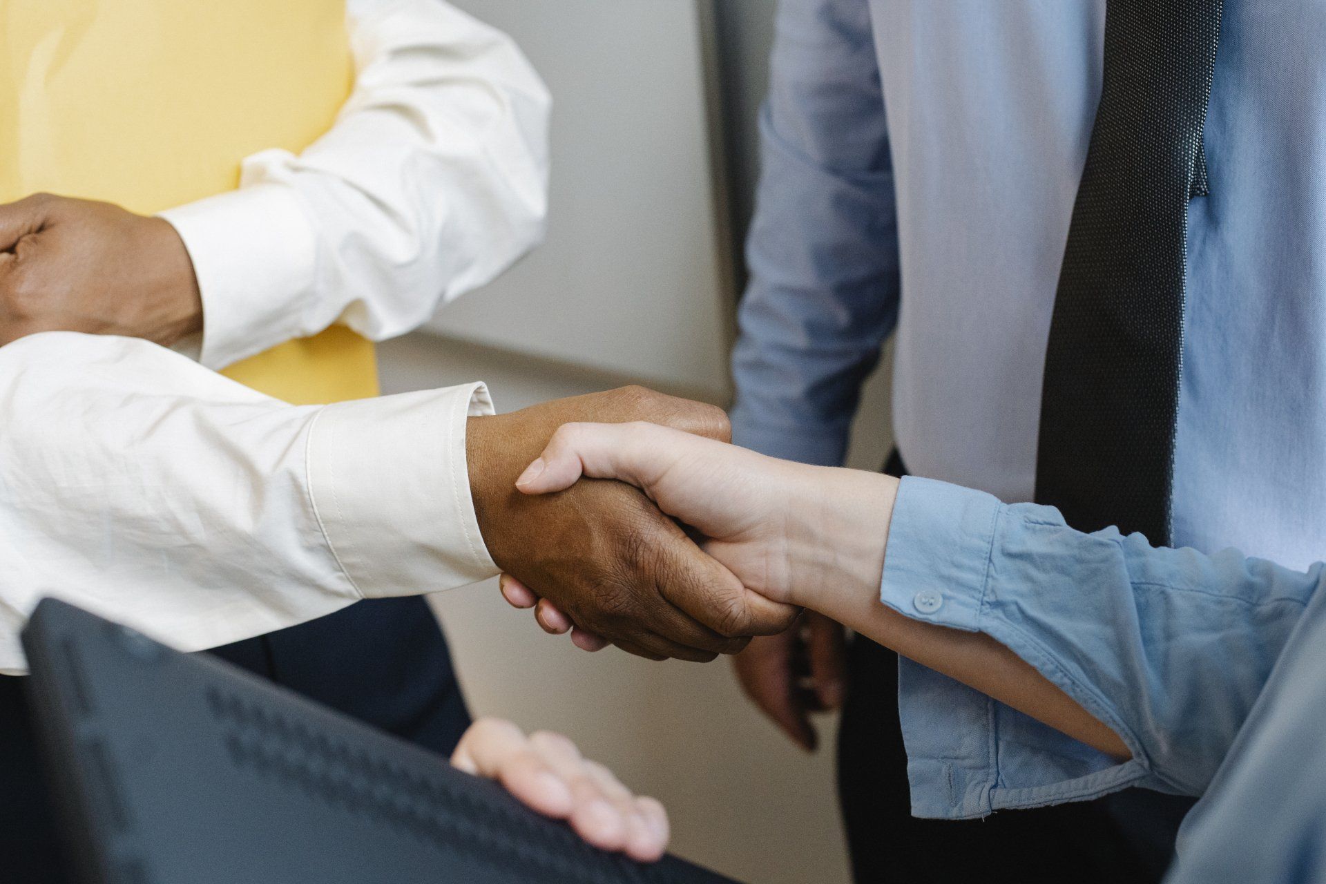 People shaking hands, a handshake in a business setting.