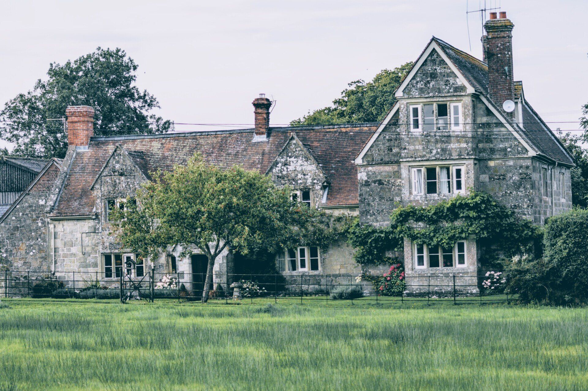 an old house with trees and lawn in front