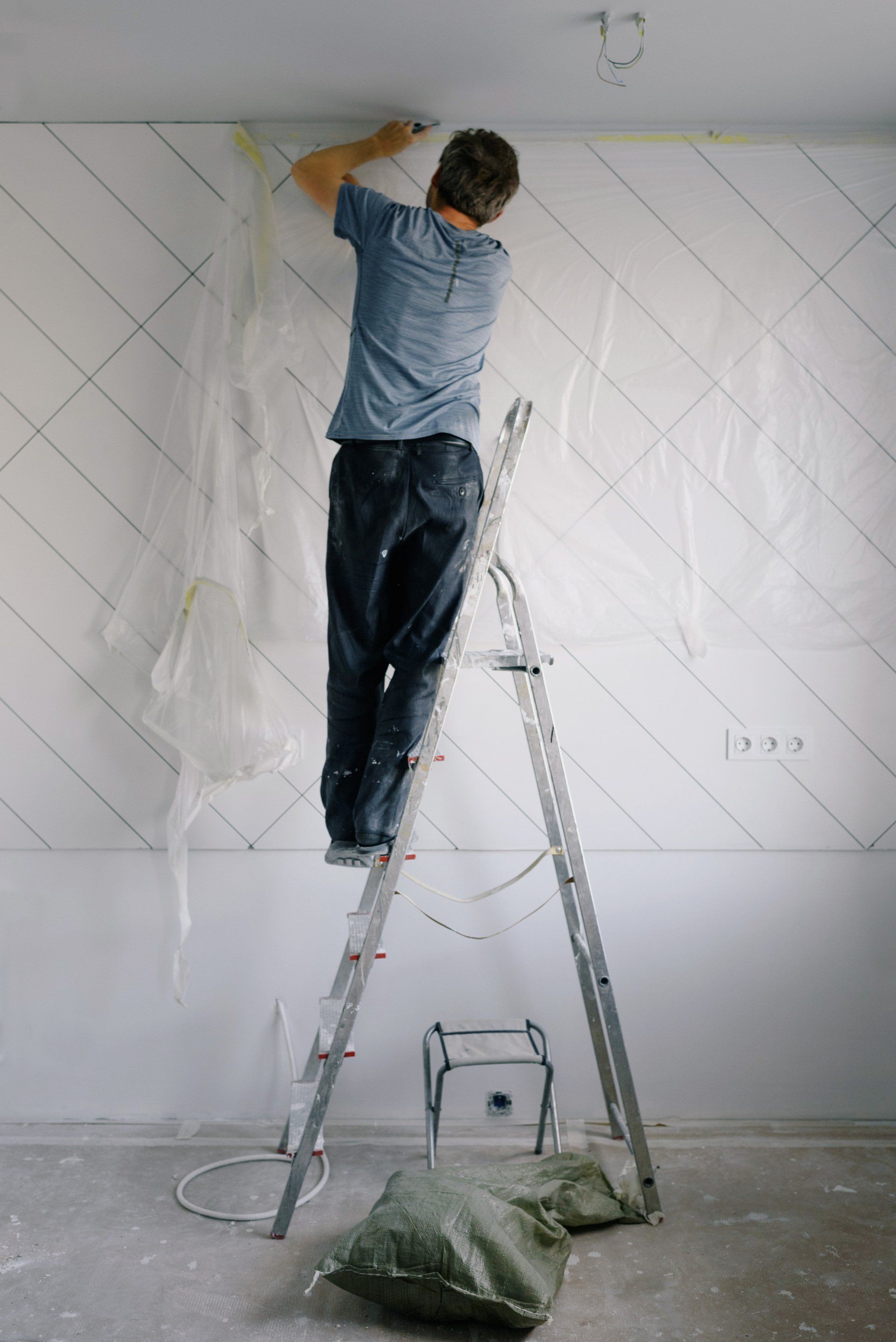 a man on a ladder by the wall