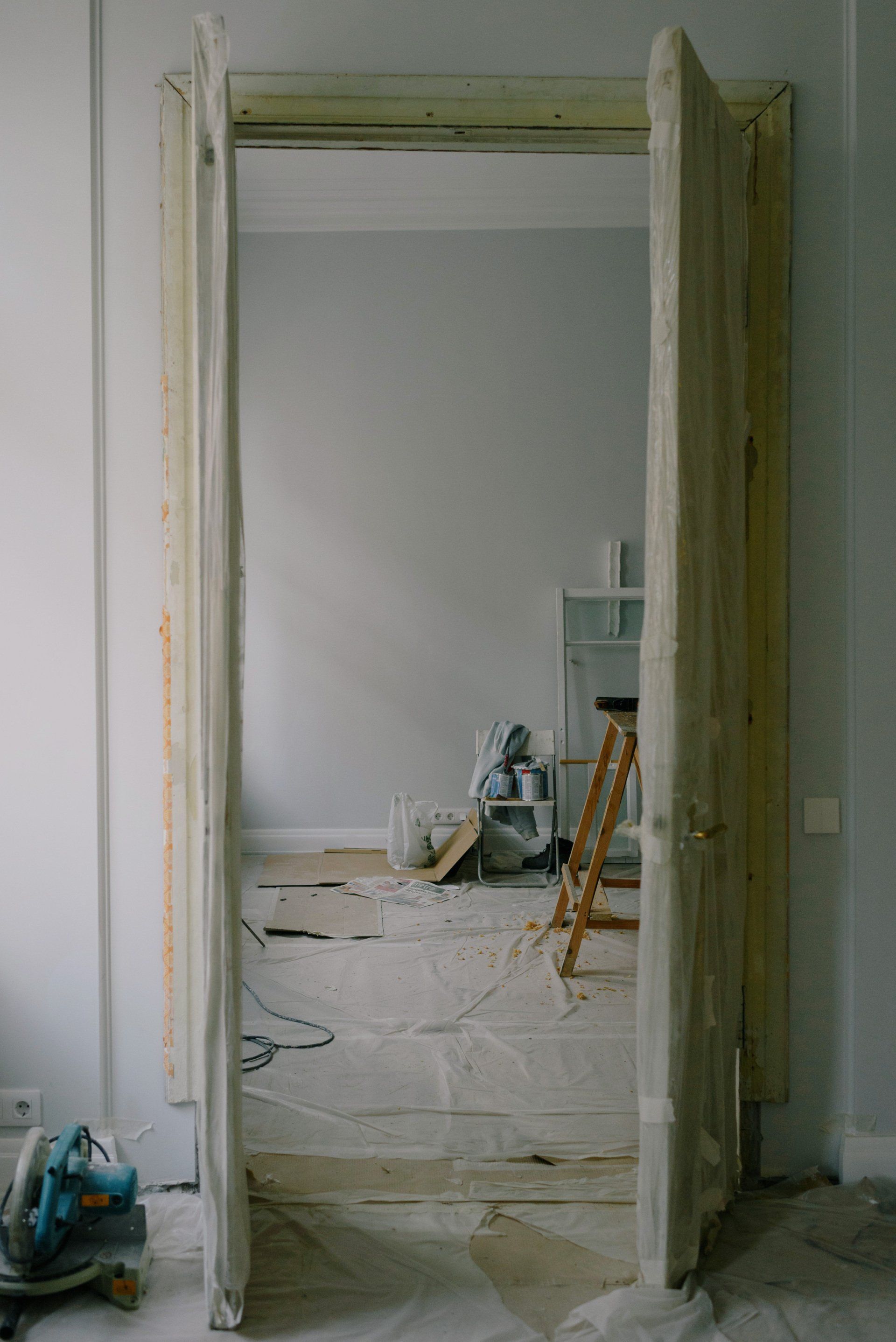 Open doorway to a room with peeling paint and renovation debris