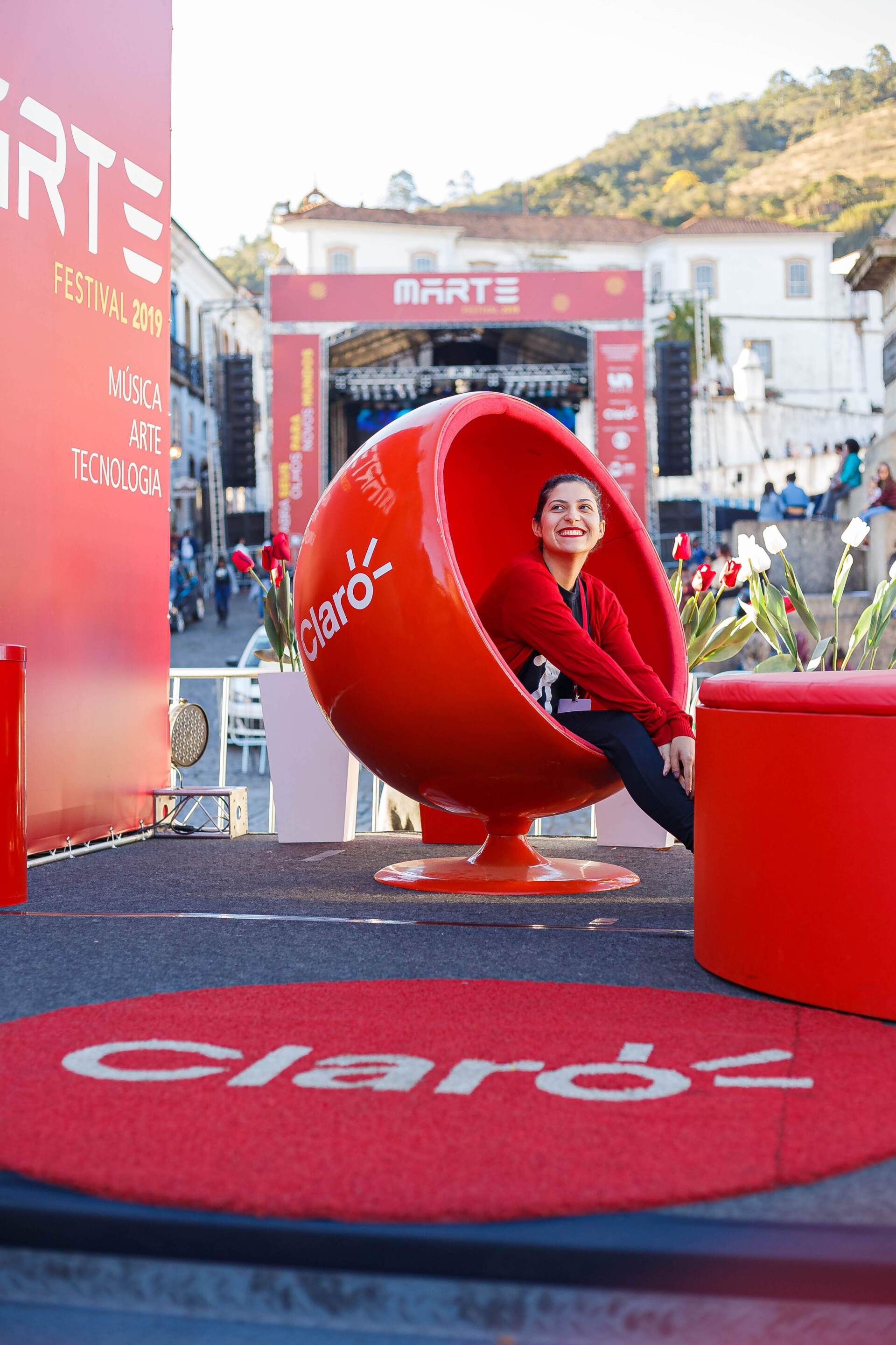 A man is sitting in a red chair with the word claro on it
