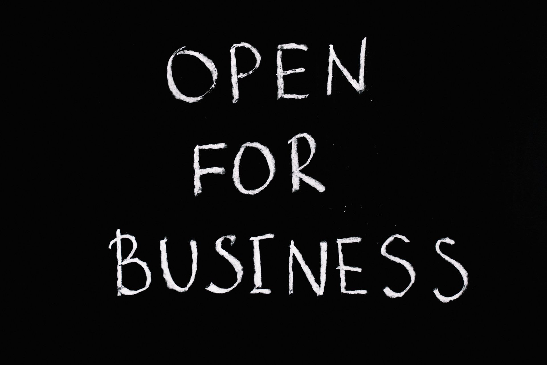 A sign that says open for business on a black background