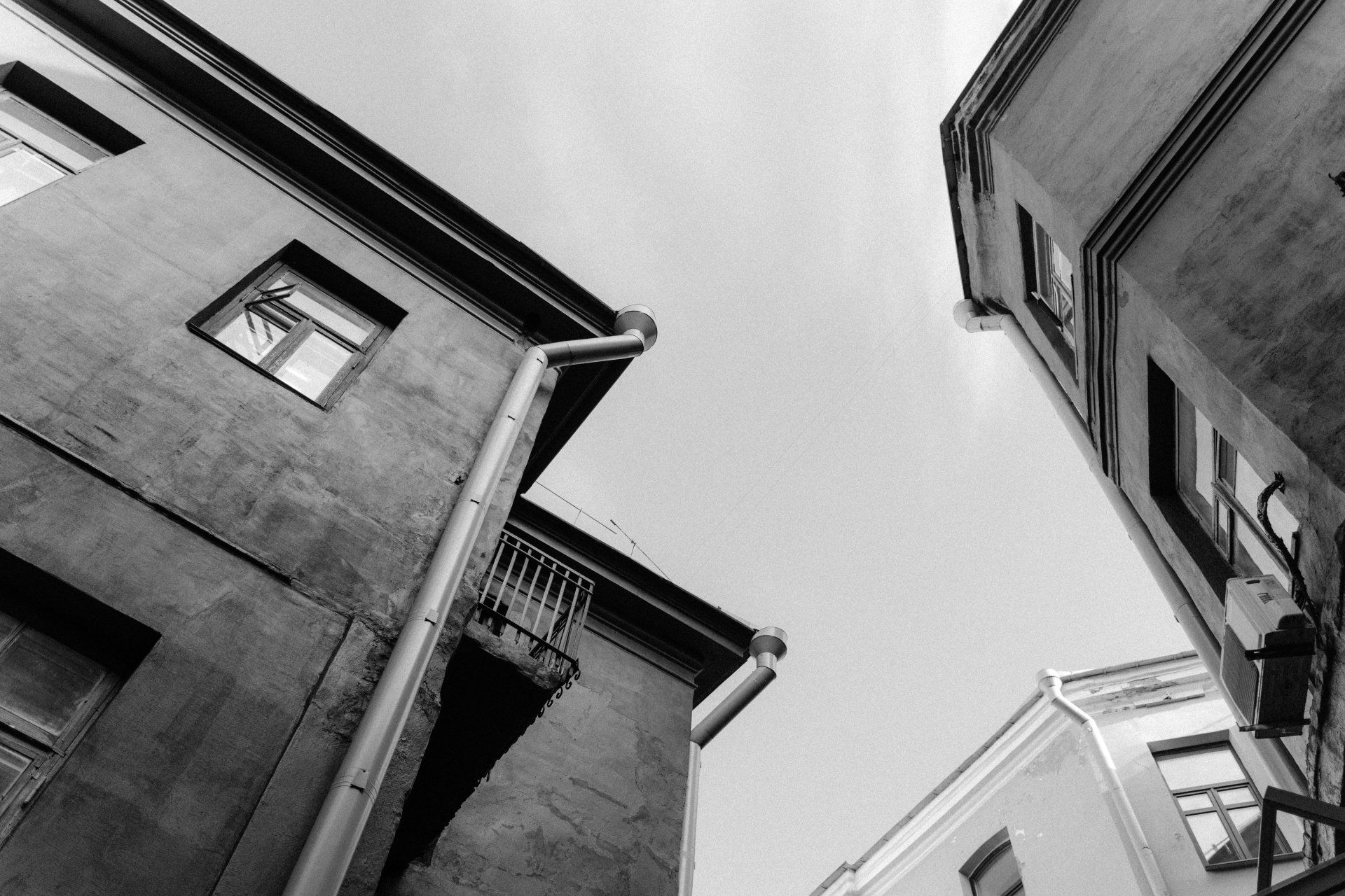 Black and white photo of a house with a downspout extending from its roof.