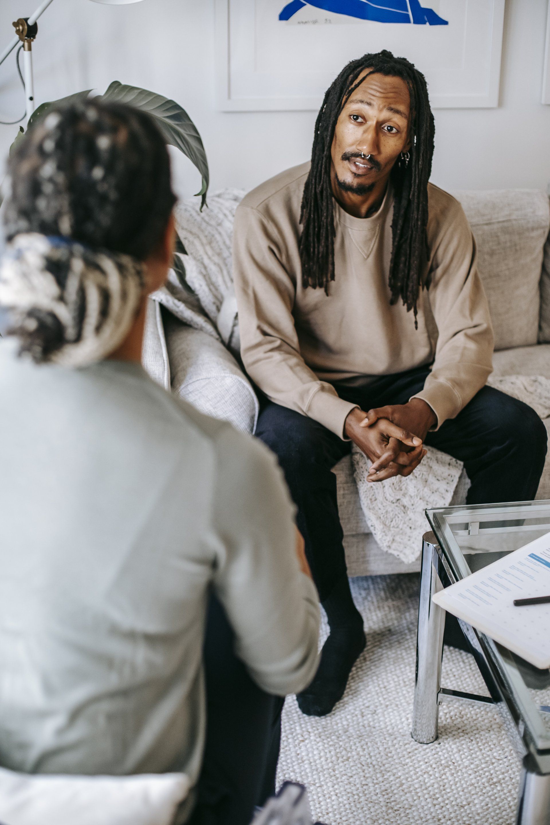 Two people talking on sofas in a bright living room during a counseling or interview session