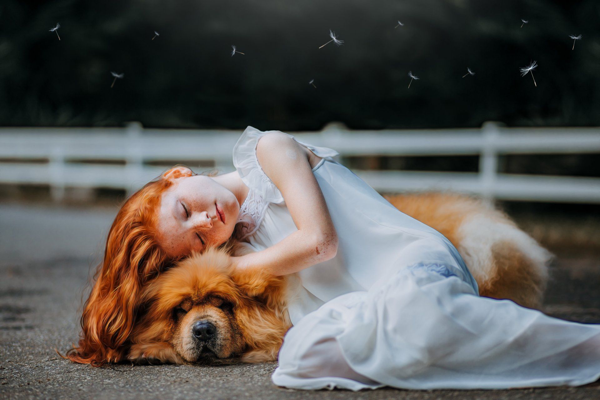A little girl is laying on the ground with her dog.