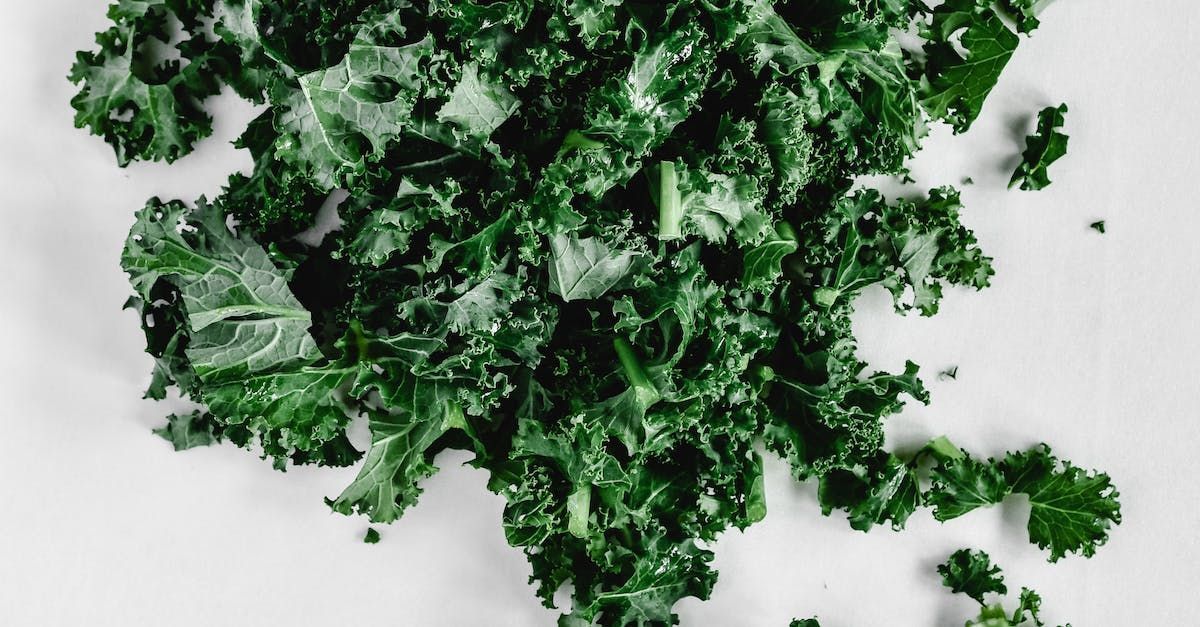A pile of kale leaves on a white surface.