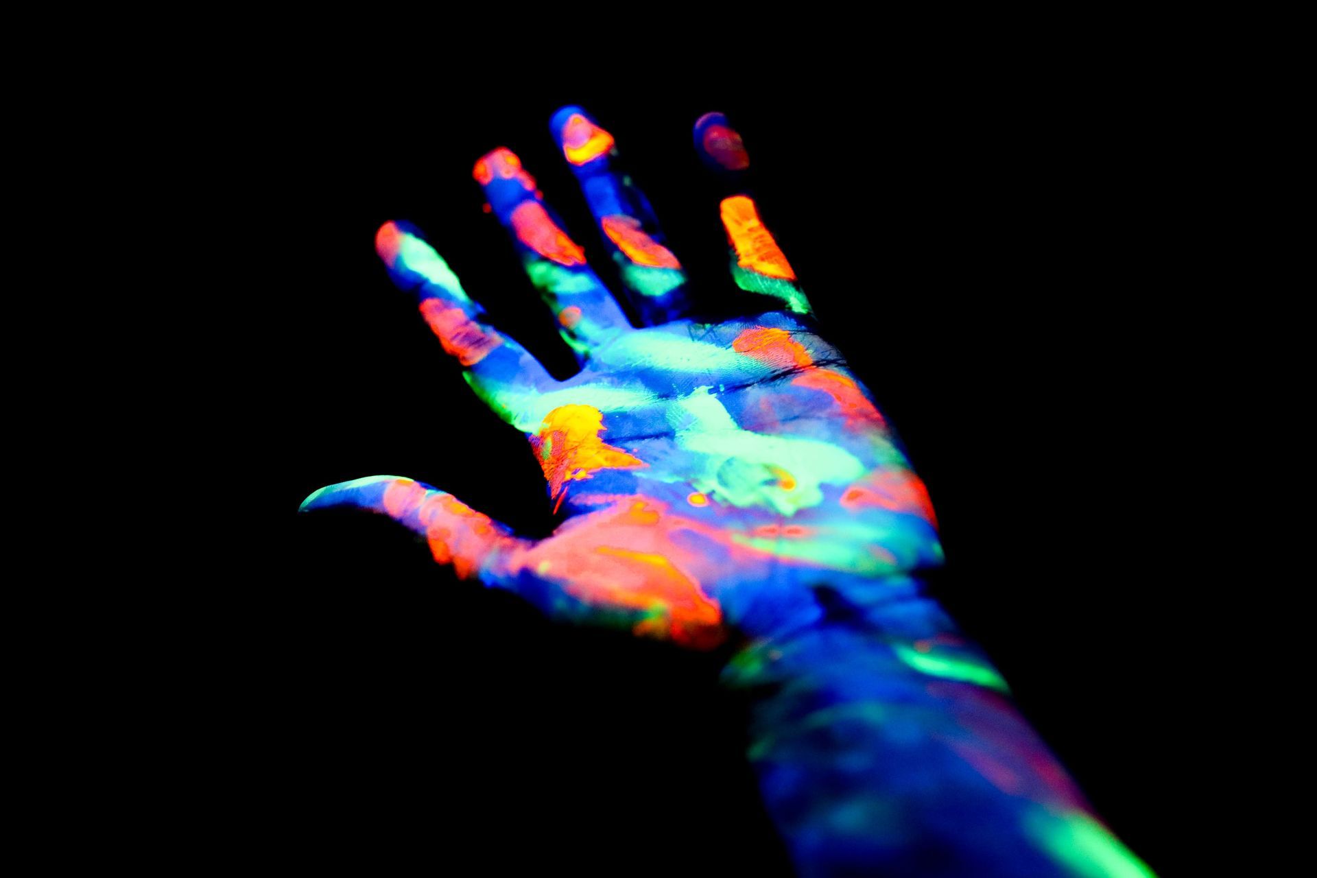 A person 's hand is painted with glow in the dark paint.