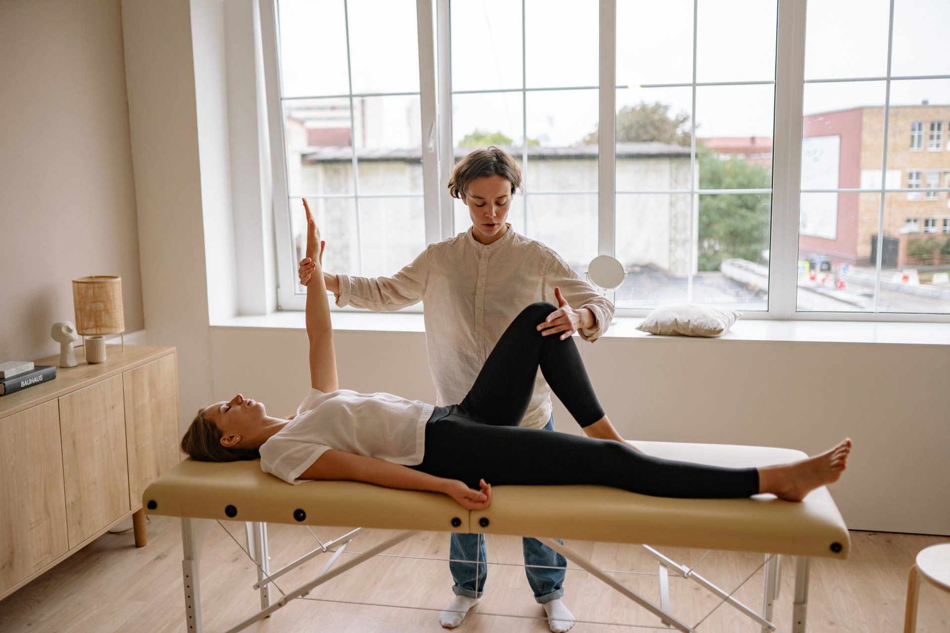 Healthcare, Chiropractors, Clinics and Private Practices A woman is laying on a table while a man stretches her leg.