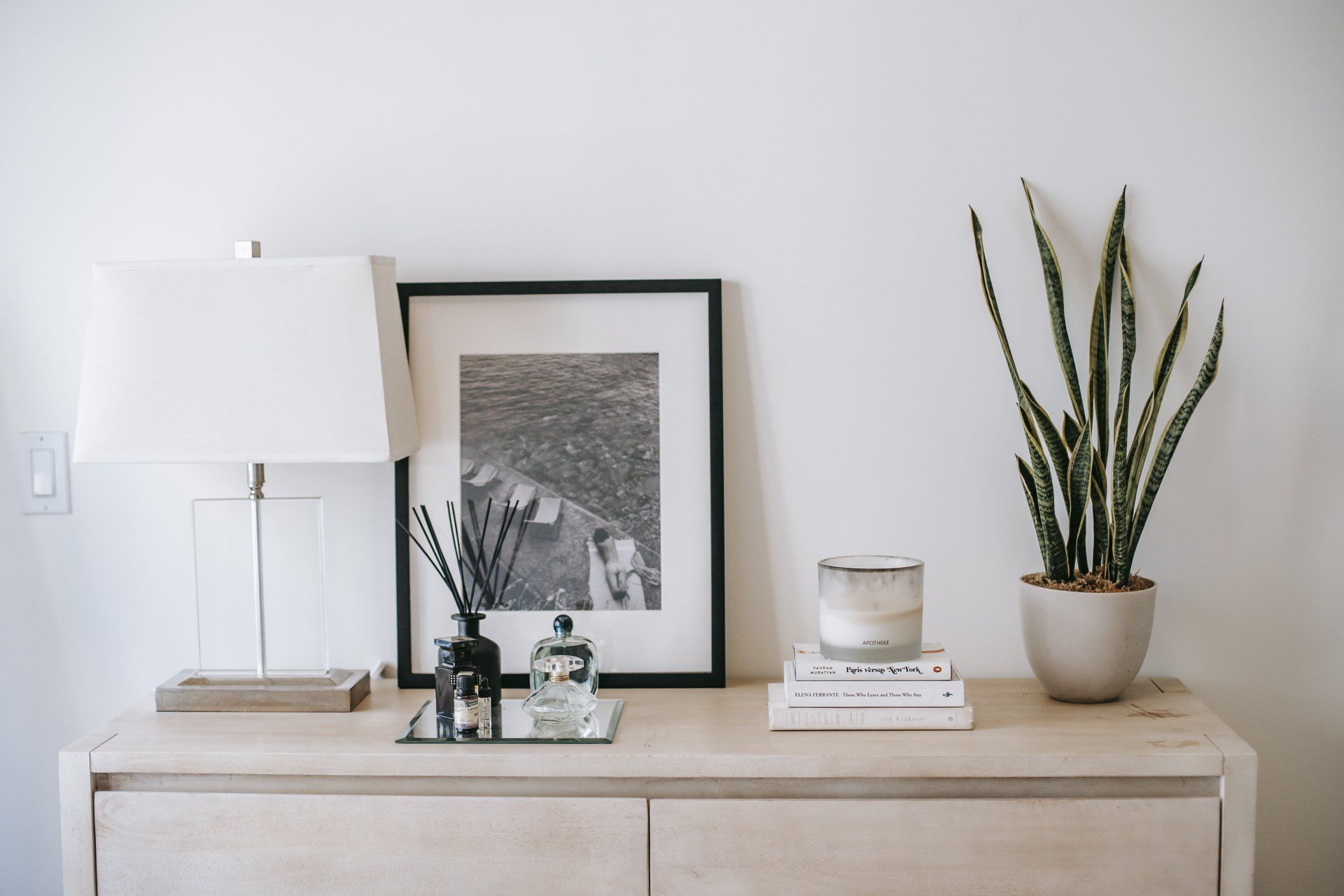 a table with a lamp a picture and a potted plant