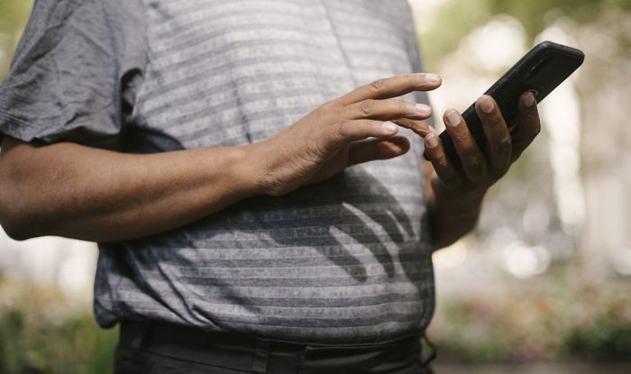 Photo of person typing on a smart phone