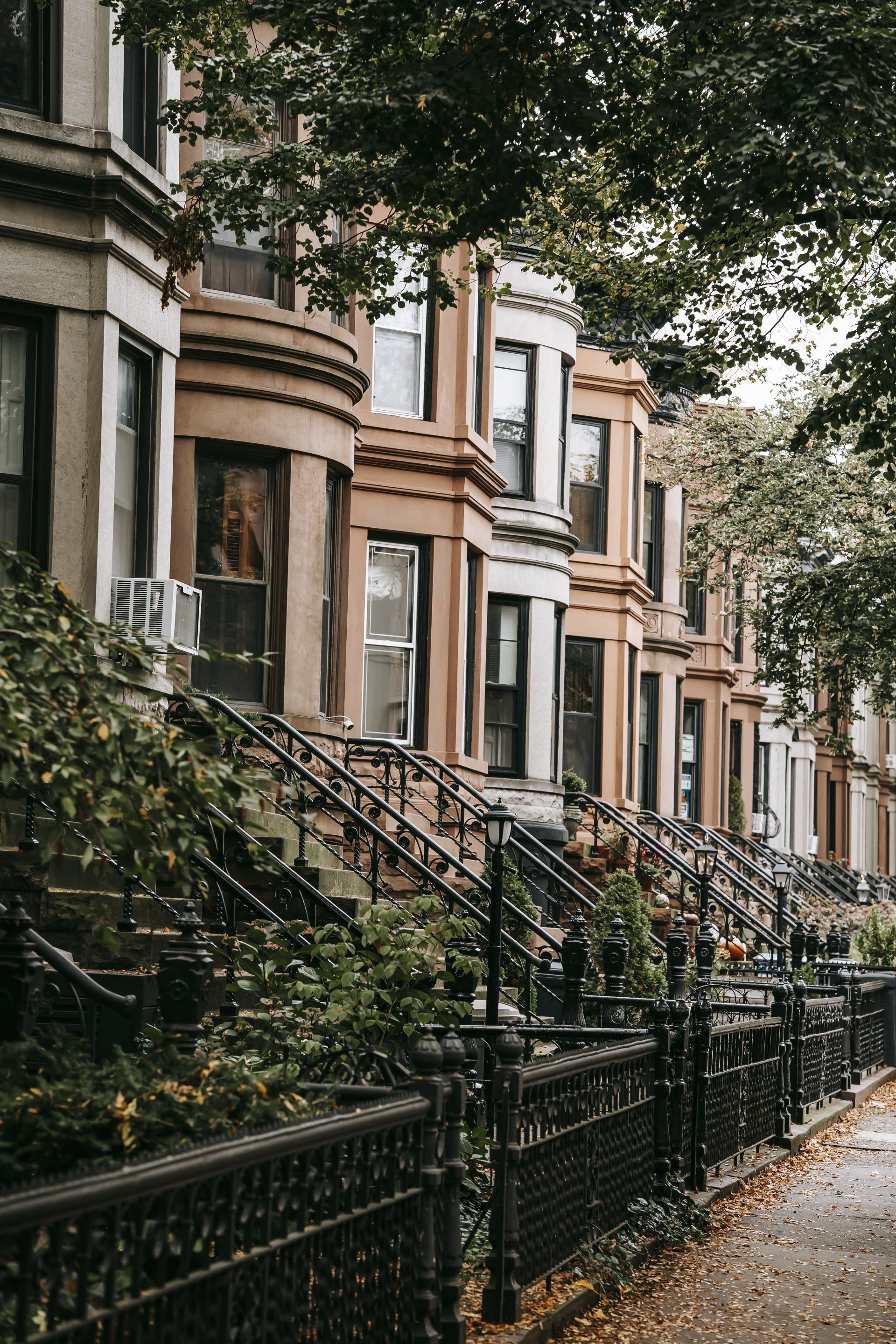 A row of houses with stairs leading up to them in a city.