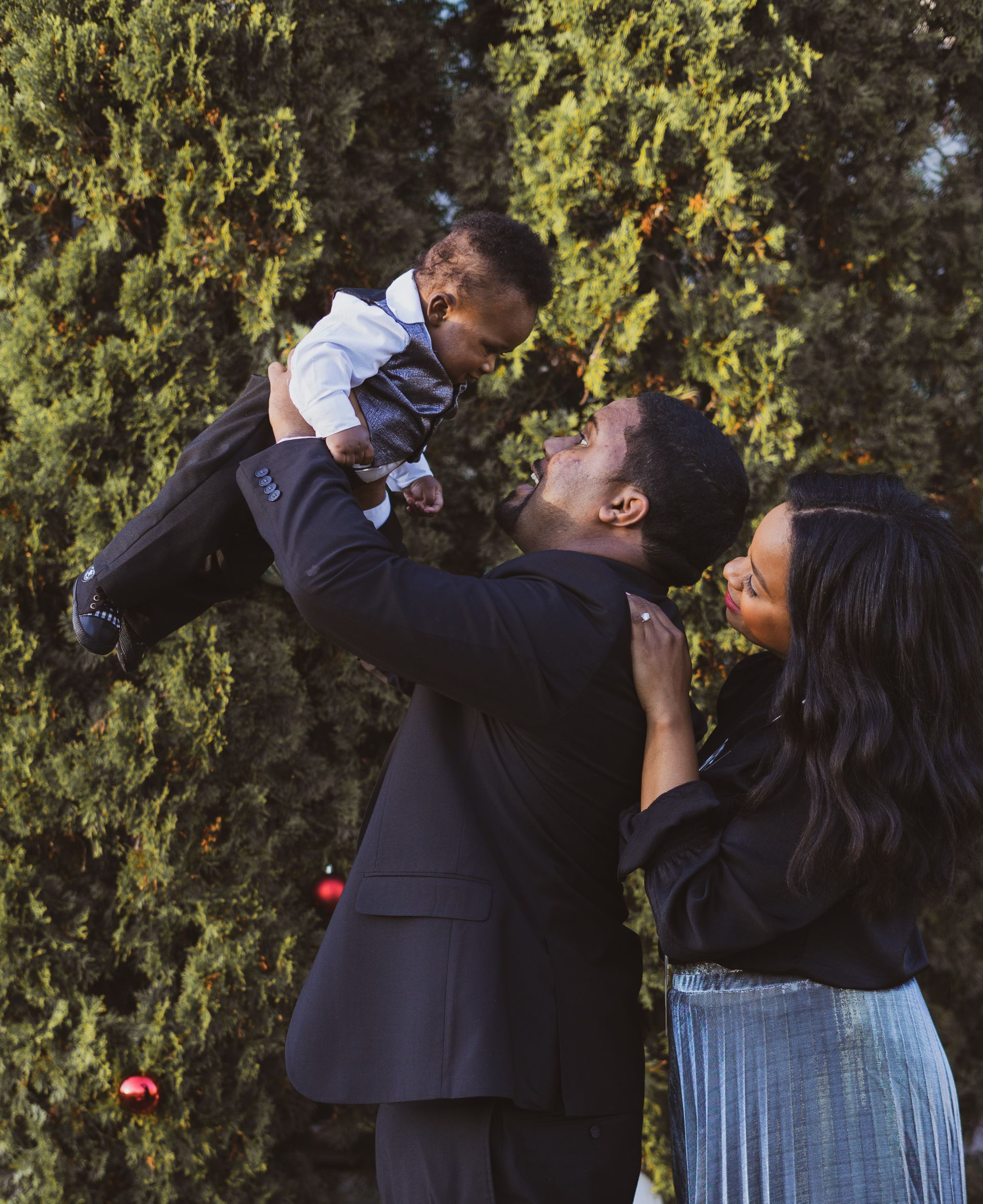A man in a suit is holding a baby in his arms.