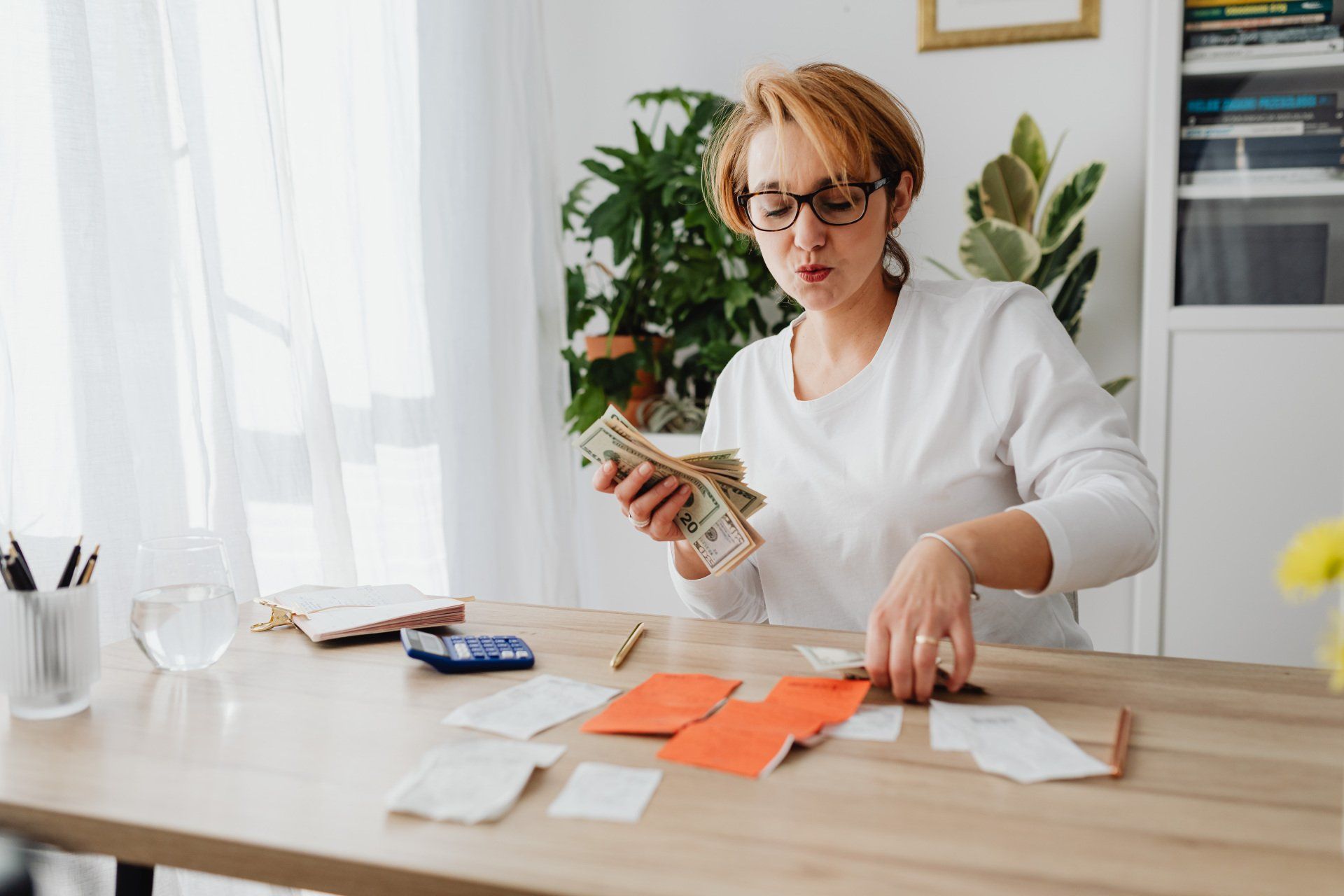 a woman is sitting at a table counting money .